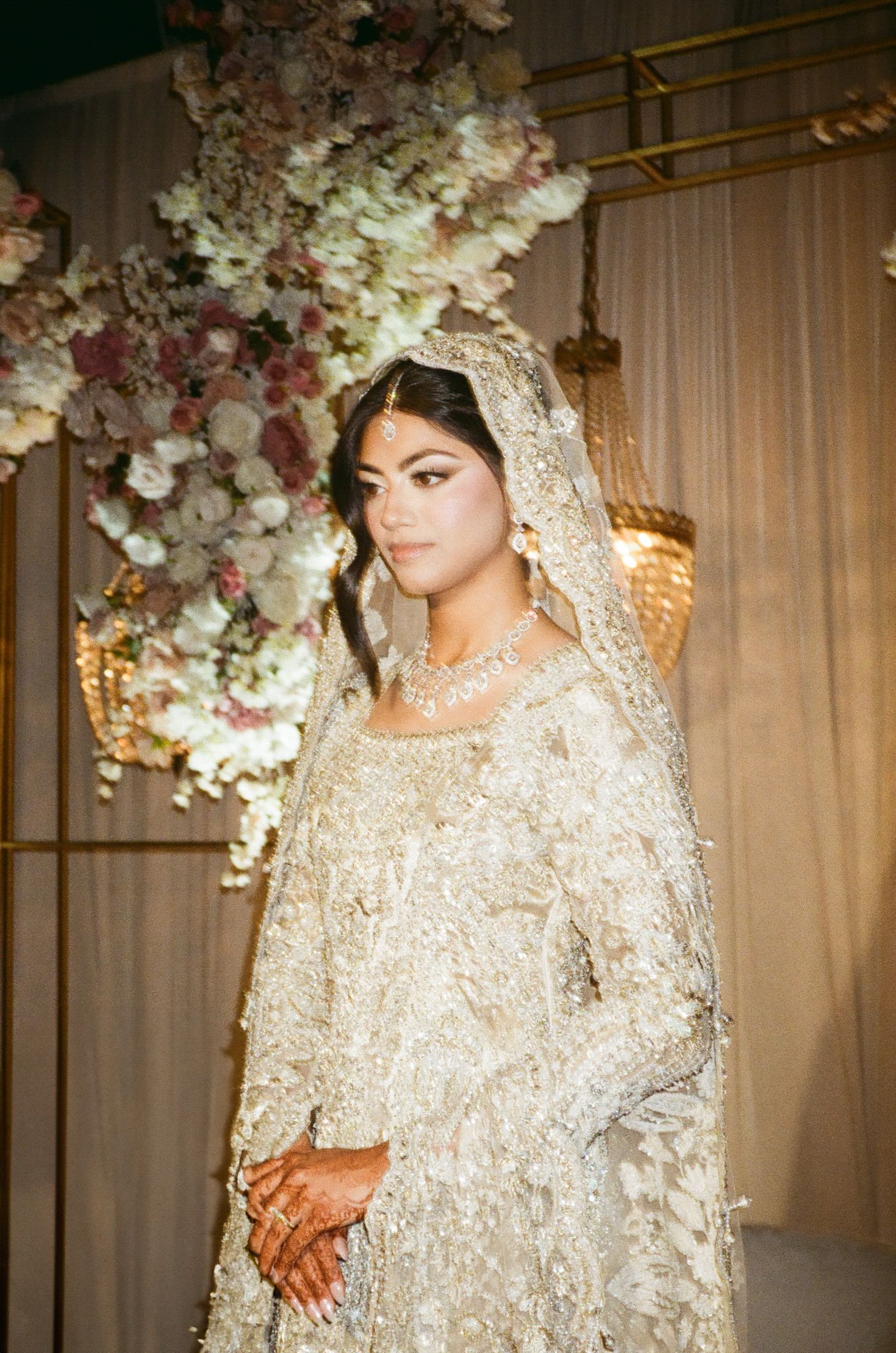 Fierce, flawless south asian bride stuns in ivory lehenga on her valima reception wedding stage at the adler Planetarium shot on 35mm film.