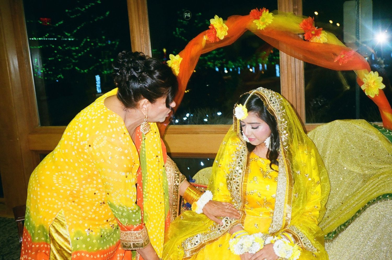 Mayoun moment in Chicago suburbs: mom helps girl settle on yellow-draped stage, beautifully framed on nostalgic 35mm film.
