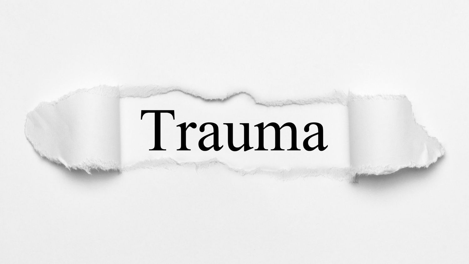 The word 'Trauma' appears in black text between torn pieces of white paper, creating a dramatic layered effect.