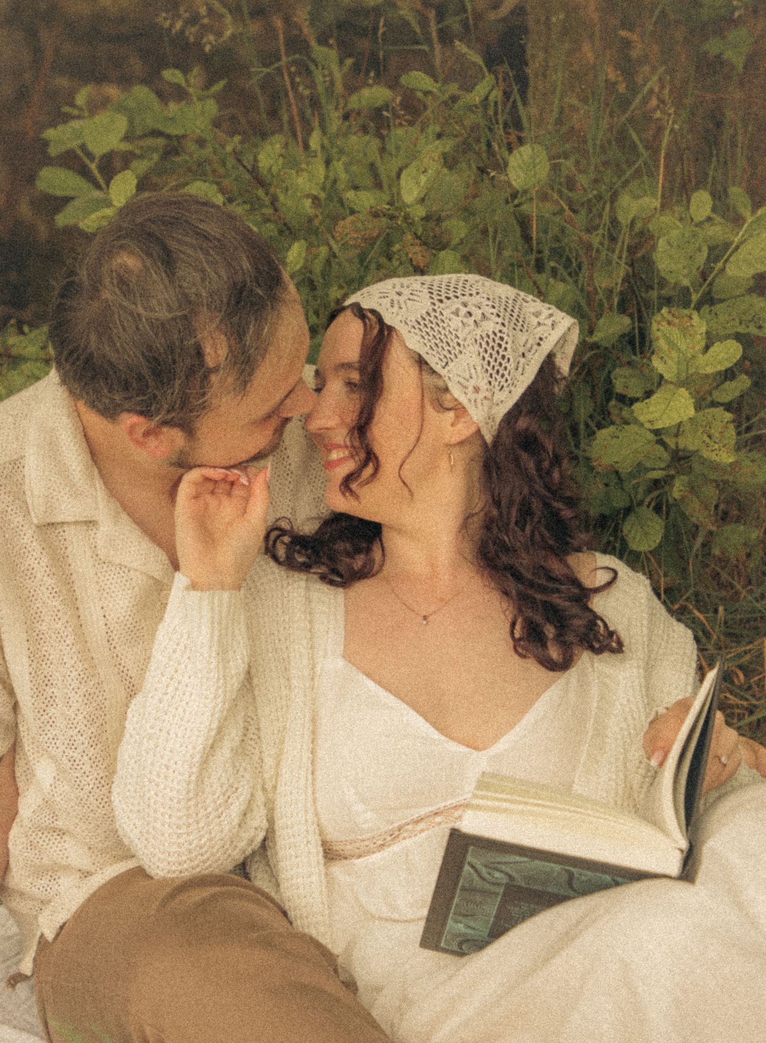 portrait-of-a-couple-in-love-sitting-under-a-tree-reading-a-book-during-an-engagement-shoot