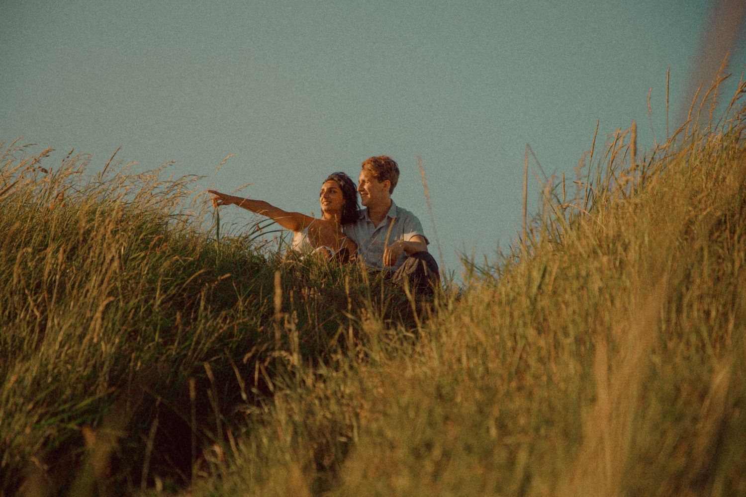 couple-sitting-atop-a-hill-in-the-summer