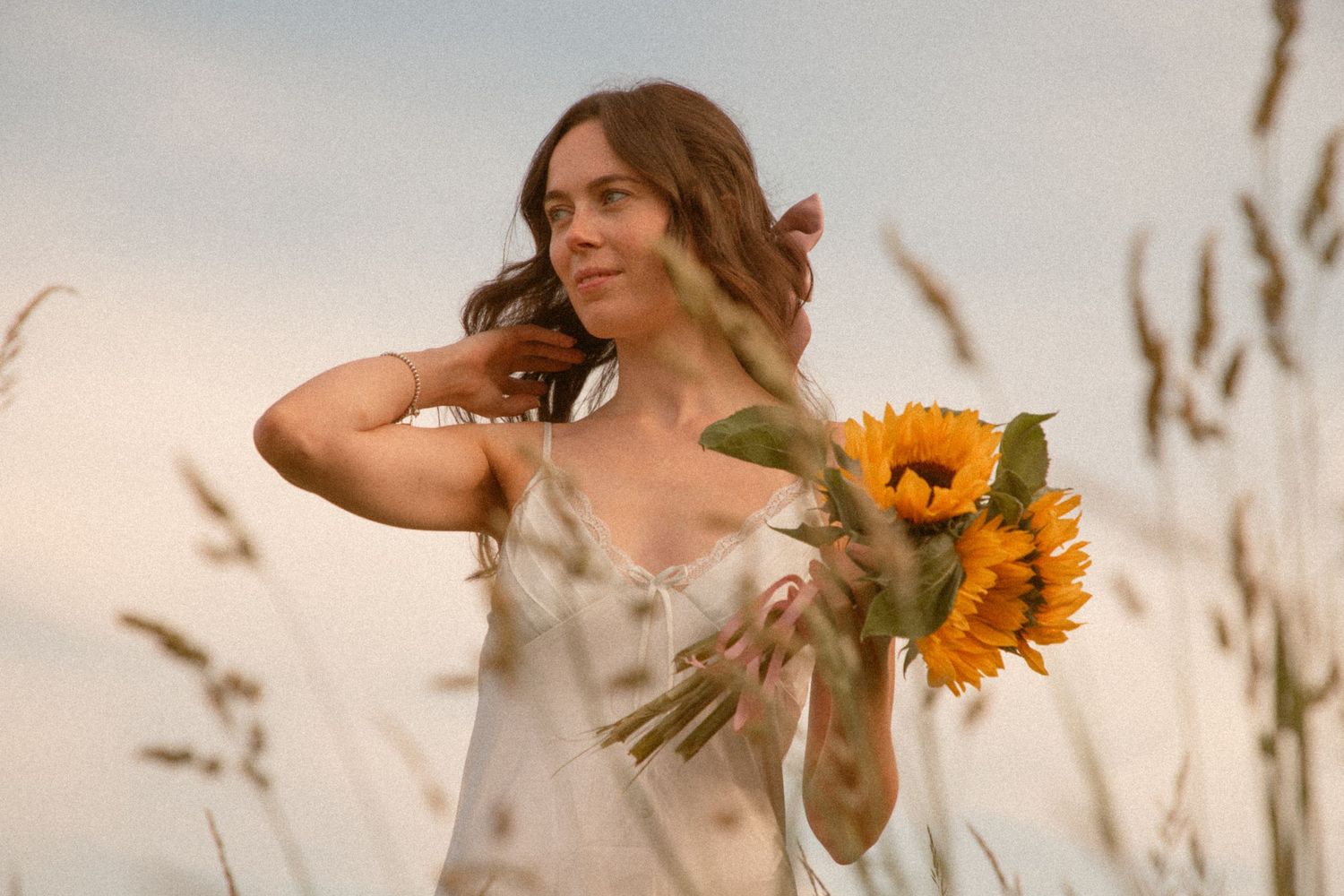 bride-holding-a-bouquet-of-sunflowers-in-the-countryside