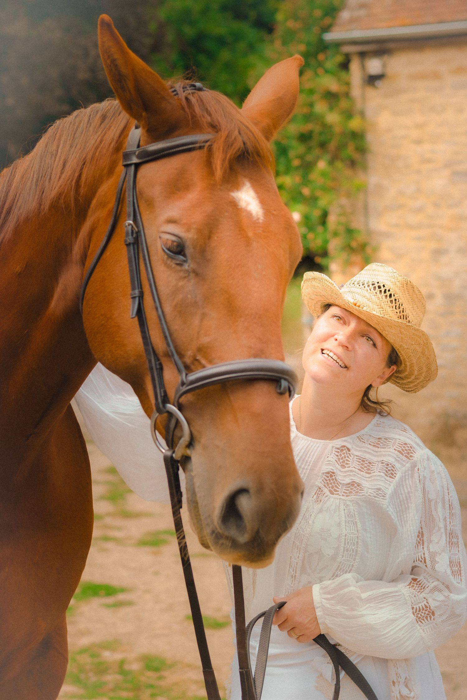 A heartwarming moment captured between a beautiful brown horse and someone in vintage white attire.
