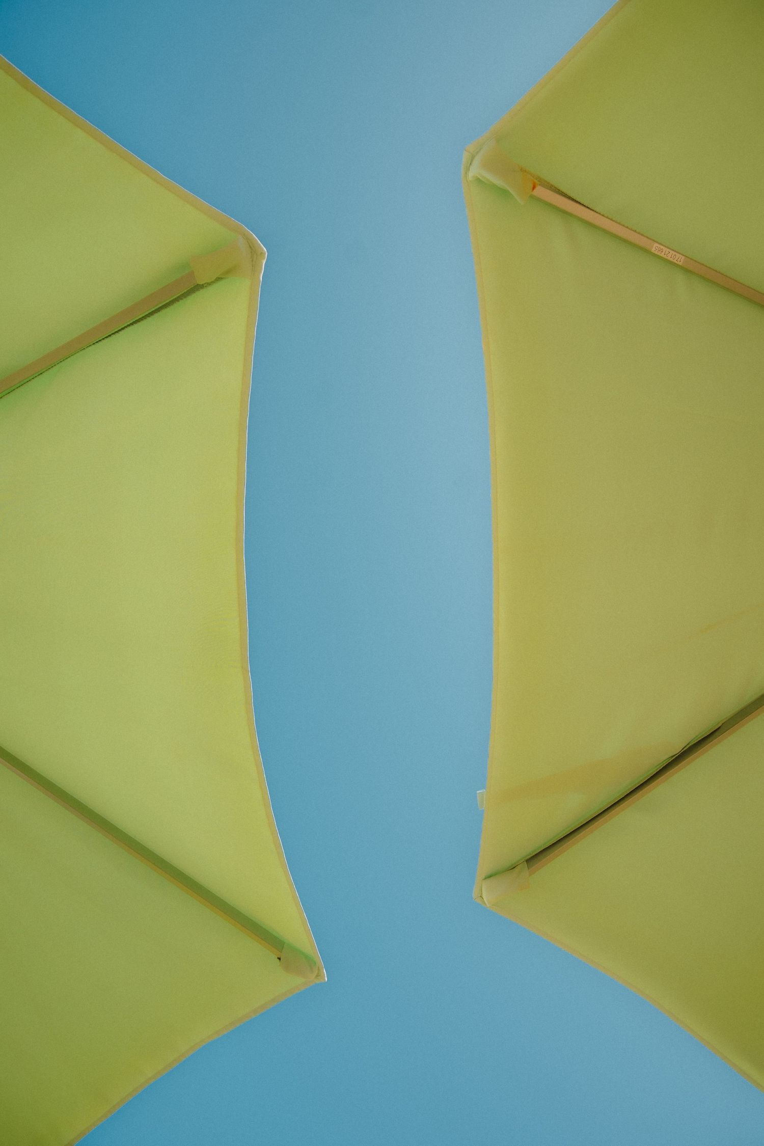 Abstract geometric pattern of yellow paper shapes against a bright blue background.