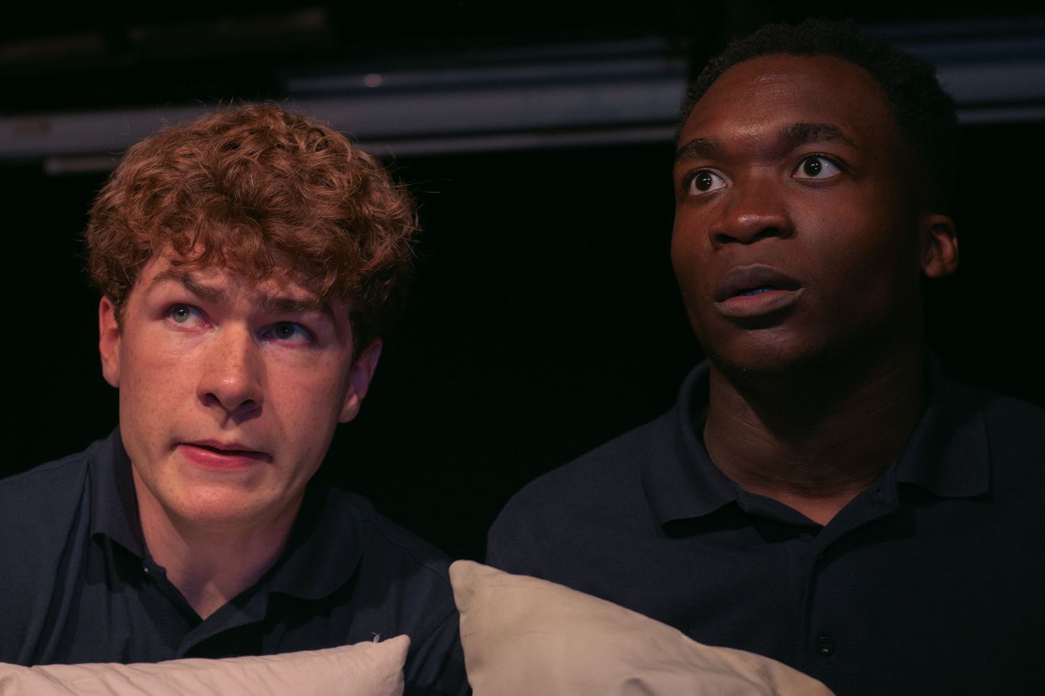 Group of people showing varied emotional expressions in low lighting.
