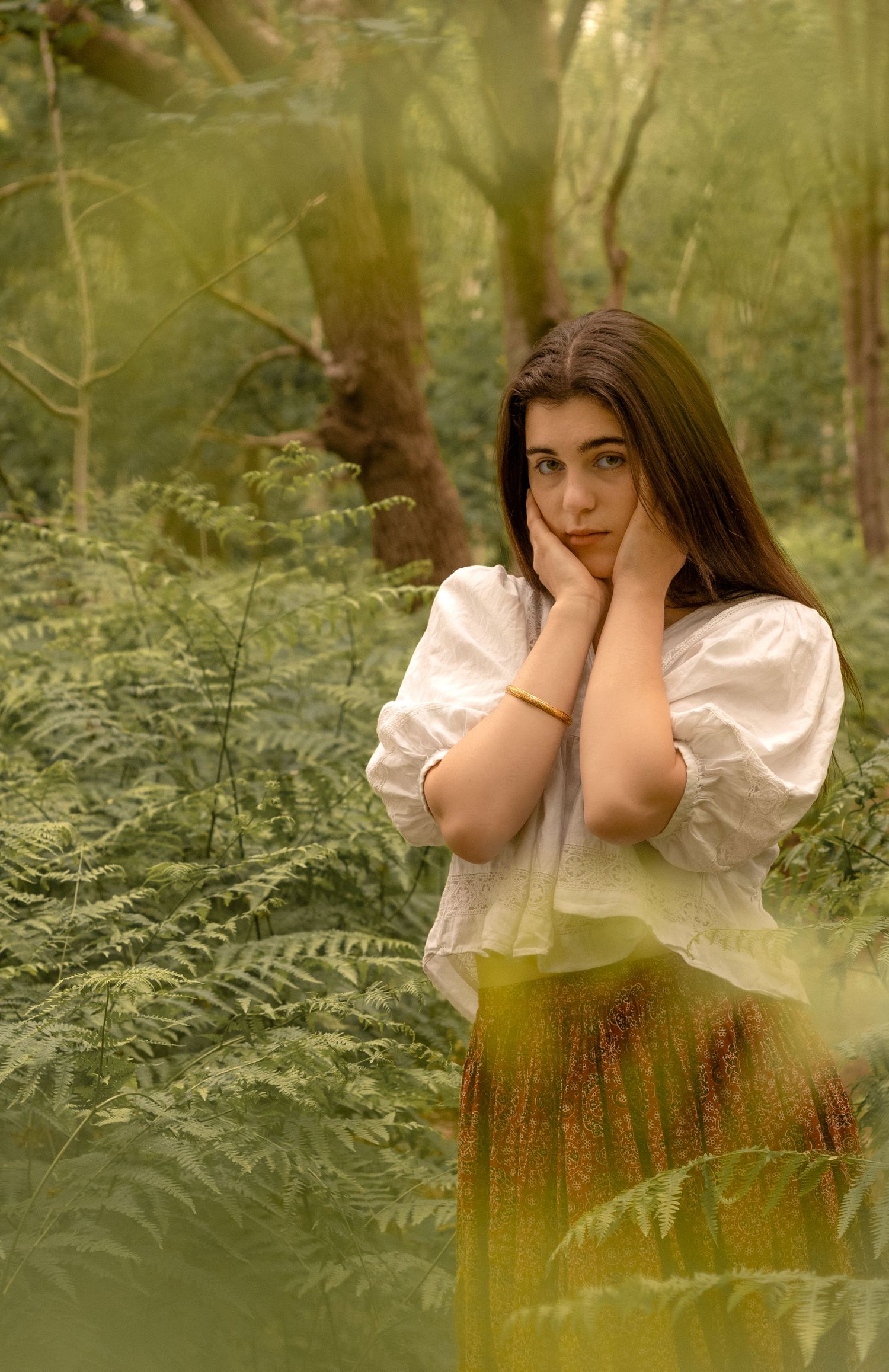 Ethereal forest portrait among ferns in soft natural light.