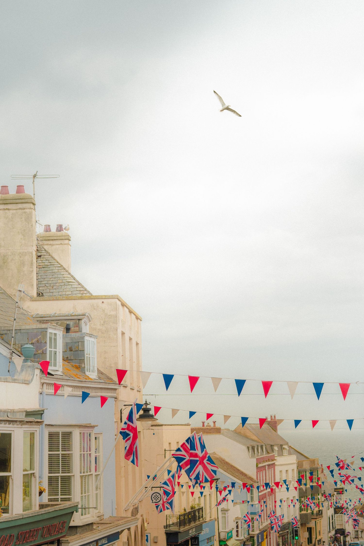 British town street decorated with red, white and blue bunting and Union Jack flags.