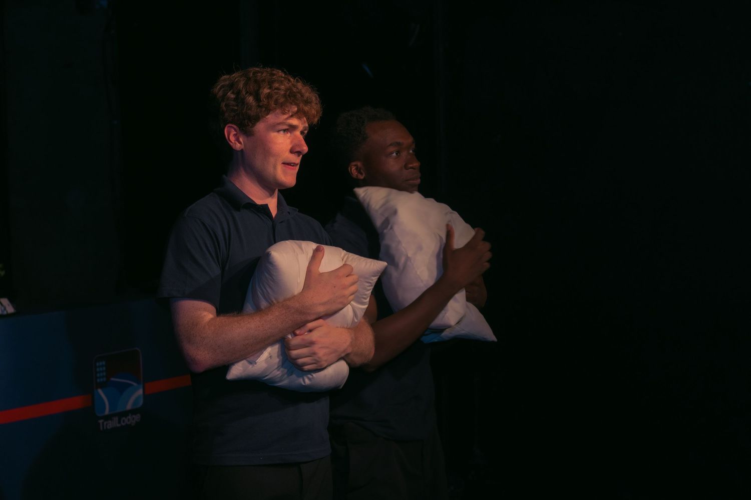 People reacting with excitement and laughter in a dark indoor space.
