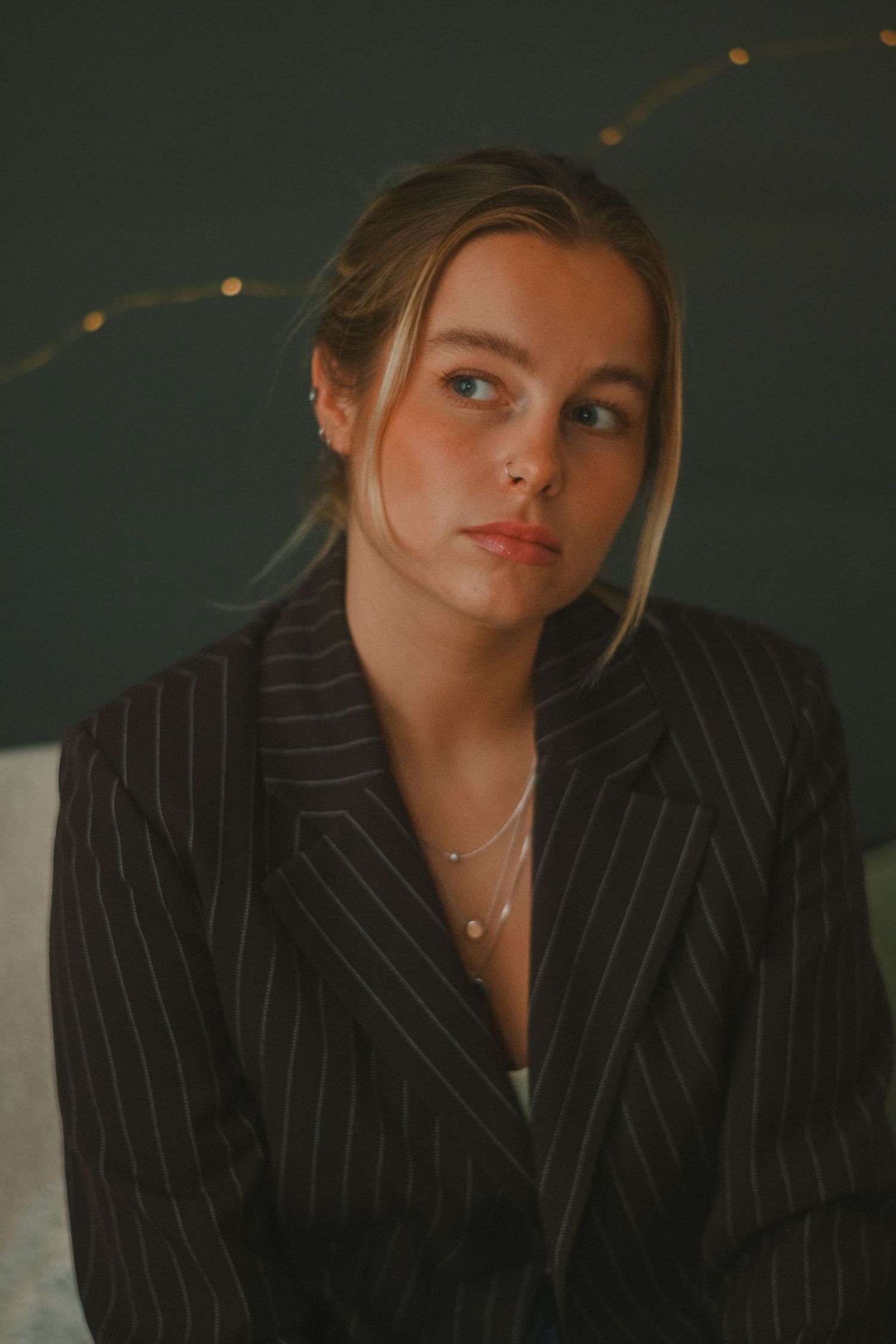Stylish portraits featuring someone in a pinstripe blazer with moody lighting.