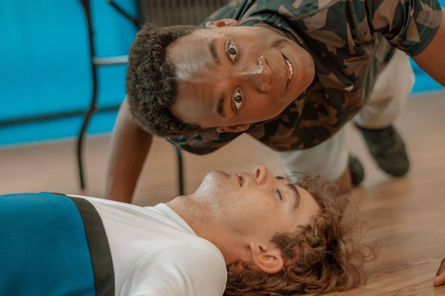 Close-up shot of two people in playful interaction during what appears to be a rehearsal.
