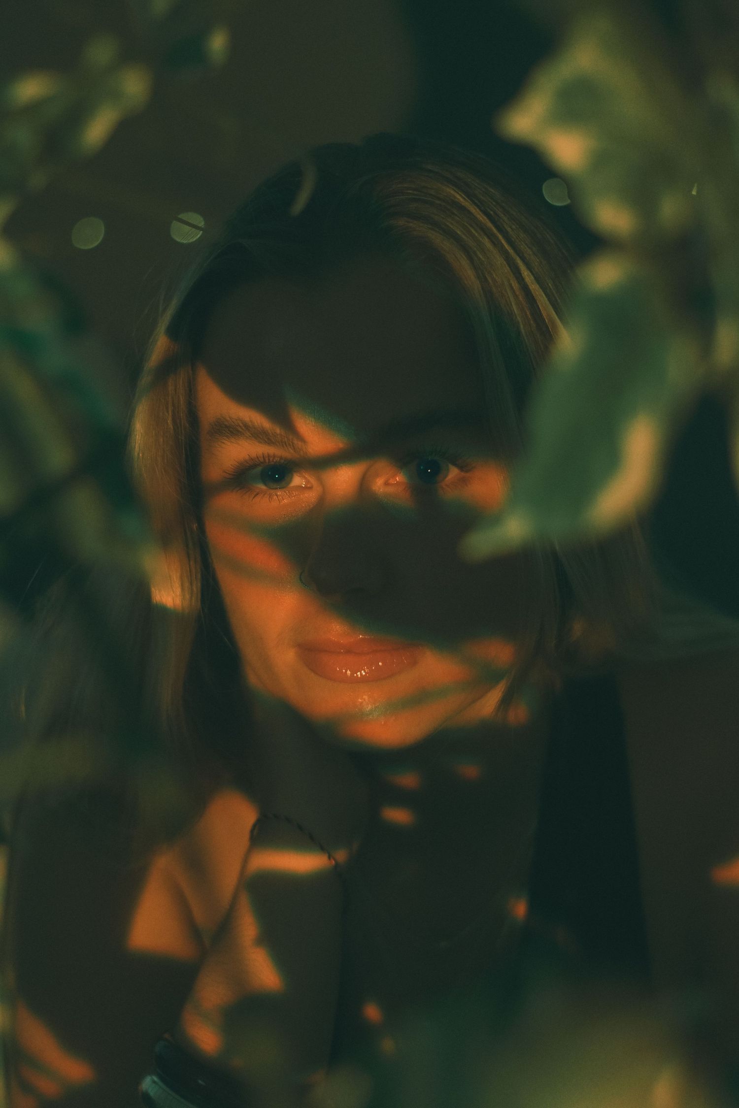 An abstract portrait with deep shadows and orange highlights creating a mysterious mood.