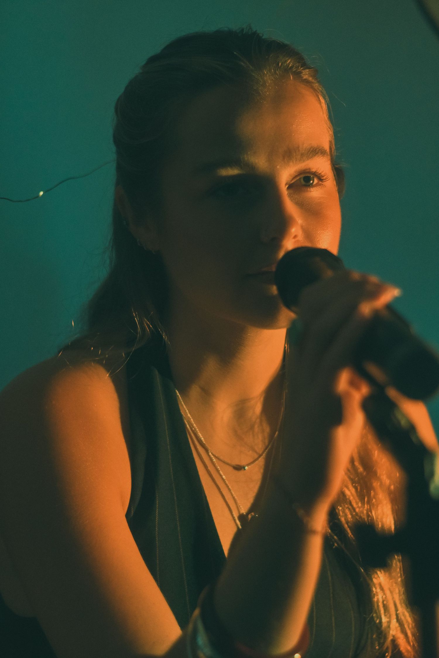Dramatic low-light performance shots with teal lighting effects.