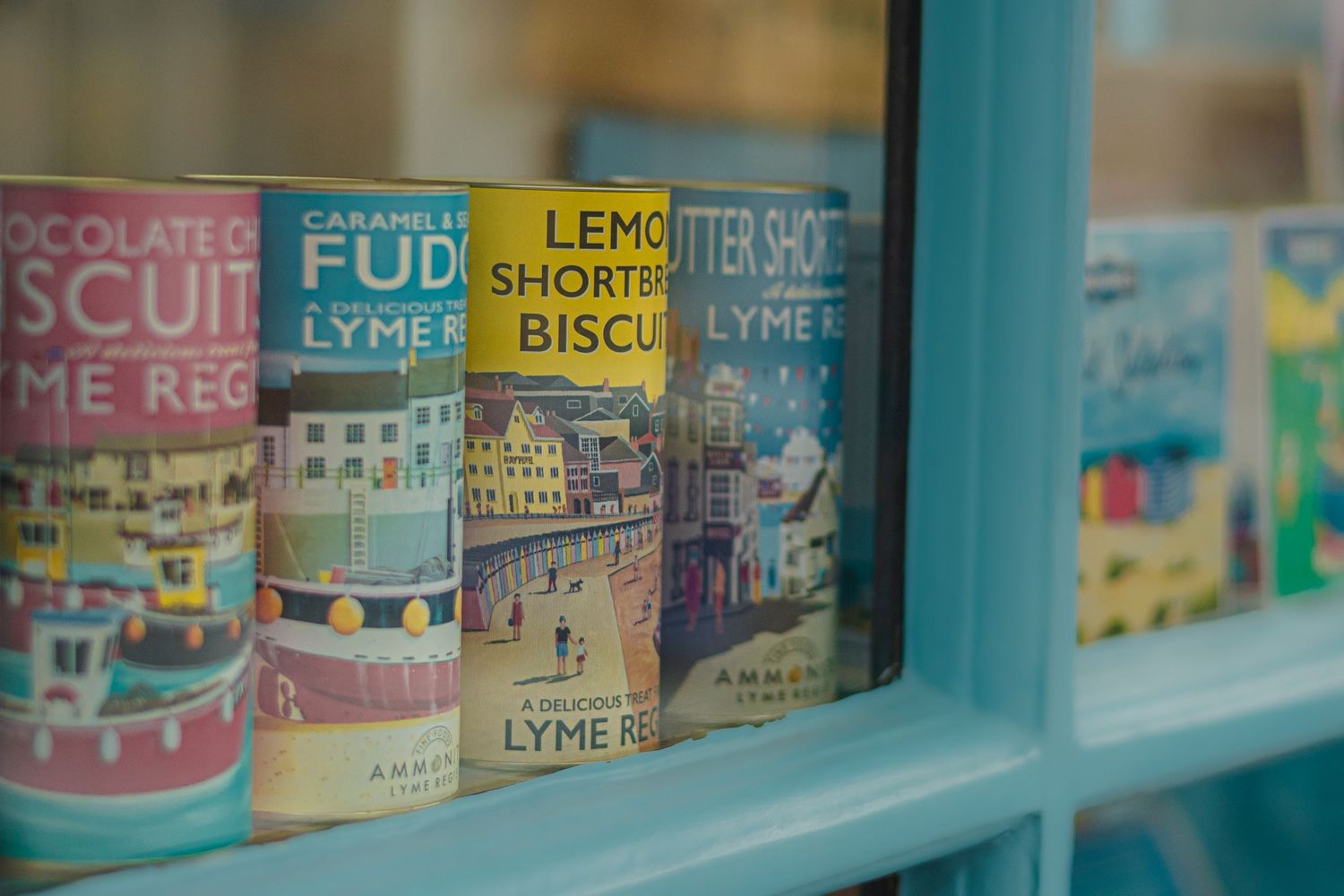 Vintage food tins and biscuit boxes displayed on retro-styled blue shelves.