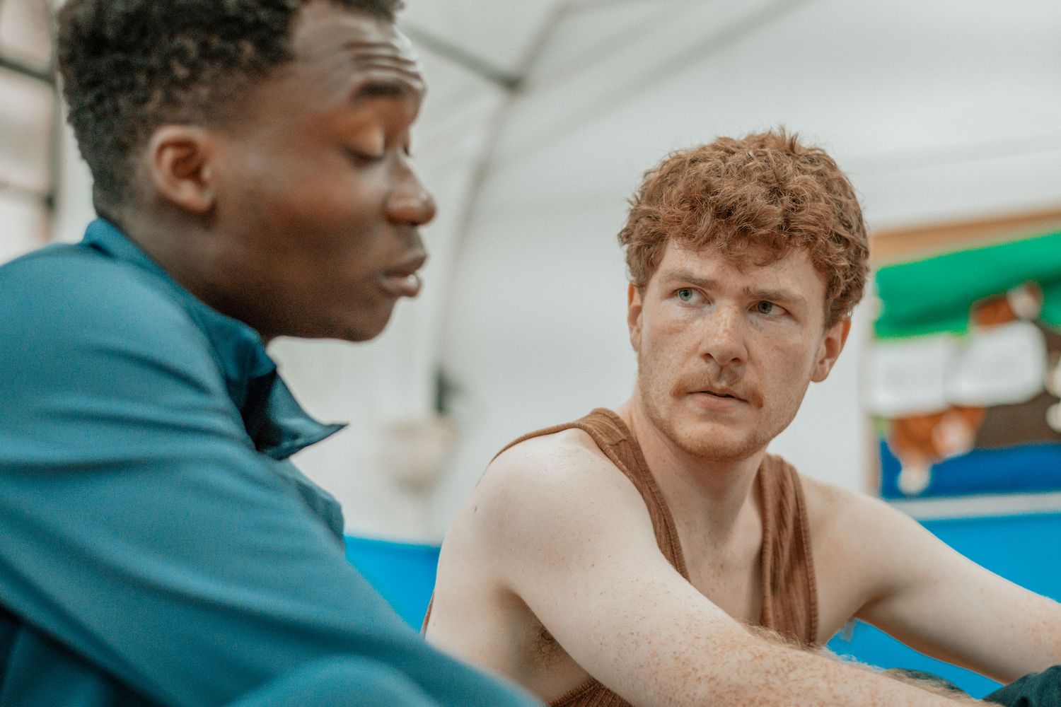 Athletes engaging in conversation during a gym training session.