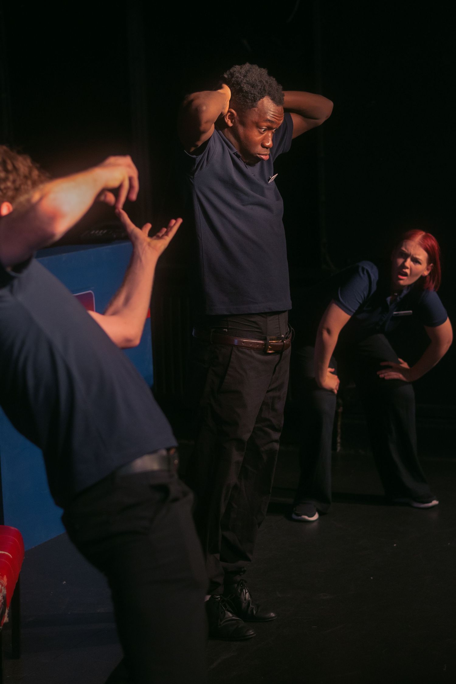 Multiple staff members participate in interactive training session in dimly lit room.