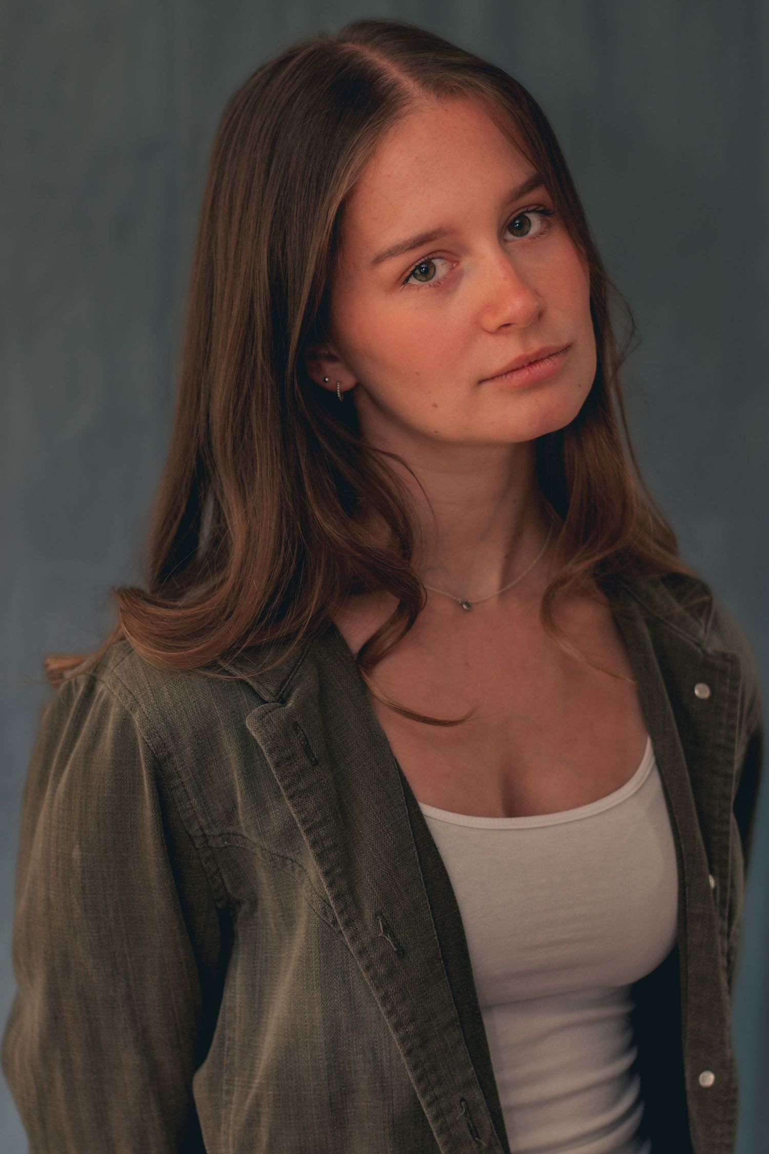 Studio portrait series in olive jacket and white tank top.