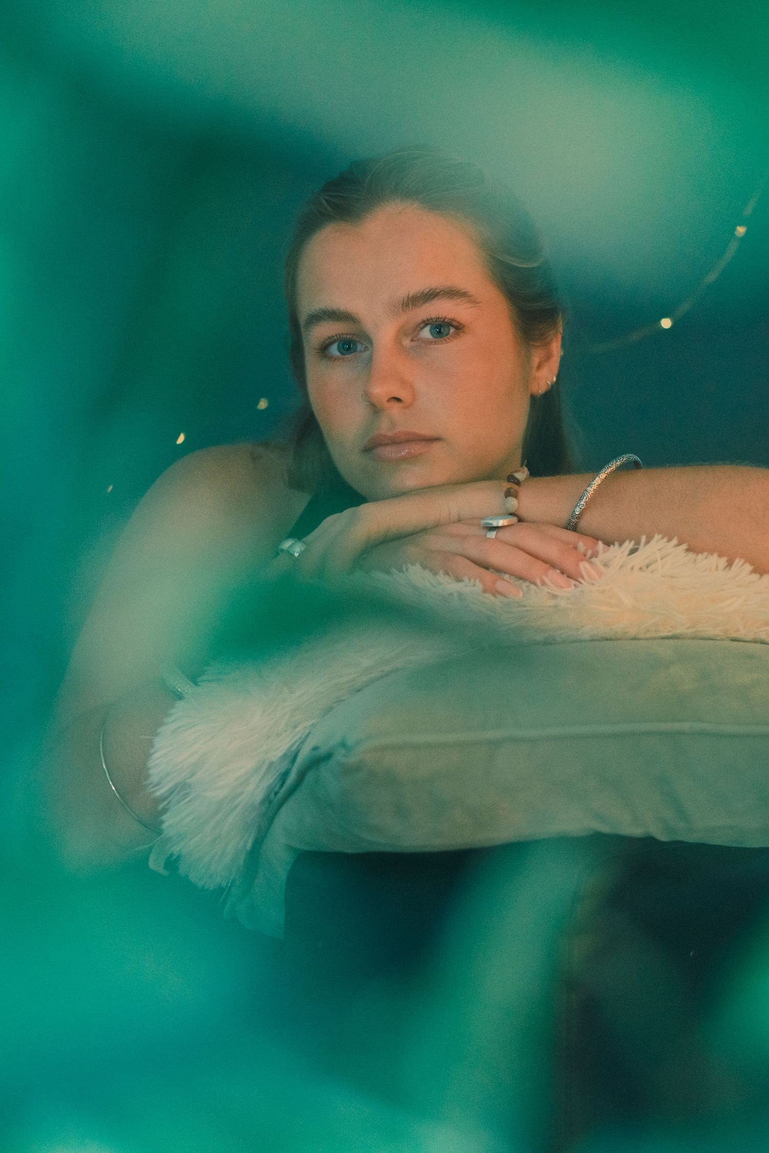 A closeup portrait shot with ethereal teal lighting and feathery textures.