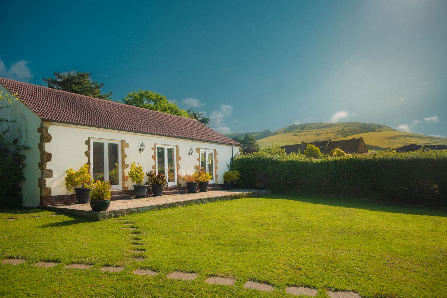 A scenic montage of Irish countryside cottages with white walls and red roofs set against rolling green hills and blue skies.