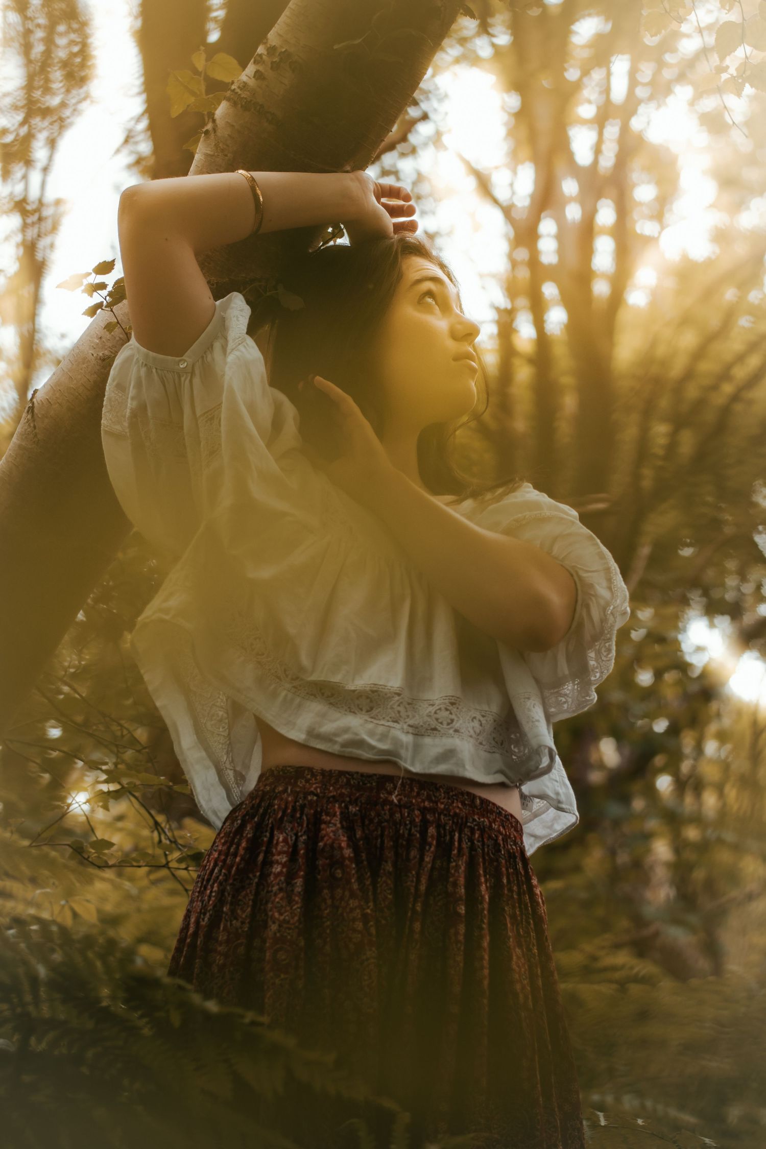 A romantic silhouette against golden sunset light in a forest setting.