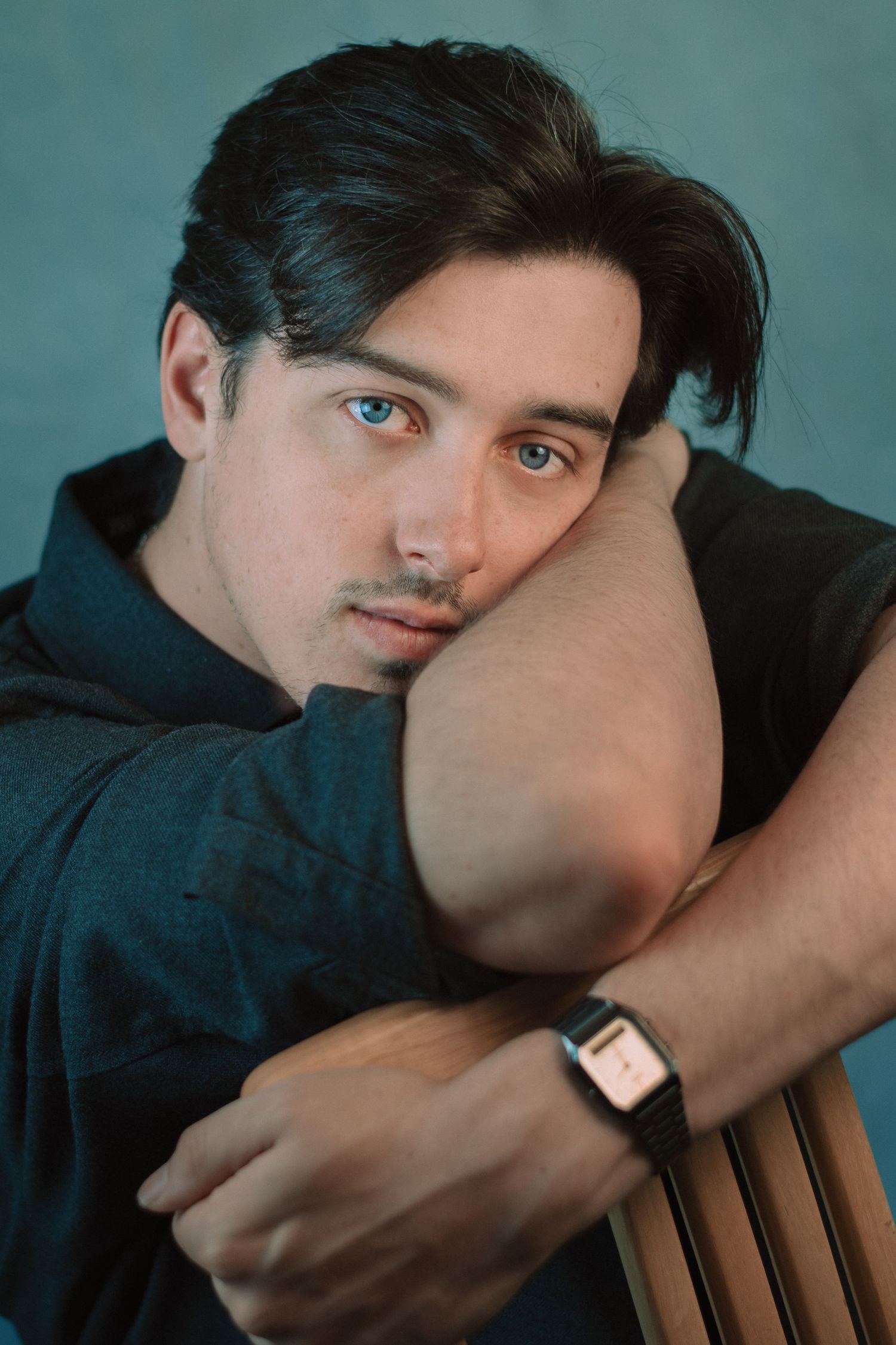 Artistic portrait series with teal background showing relaxed poses and casual styling.