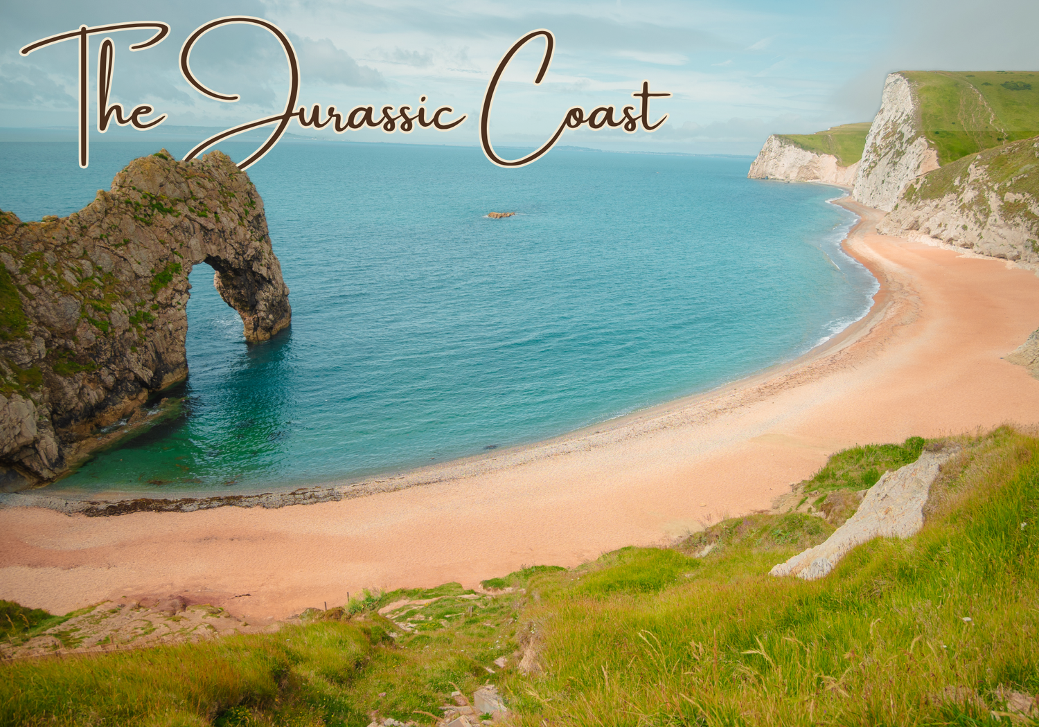 Dramatic cliffside views of a pristine beach along England's Jurassic coastline under blue skies.