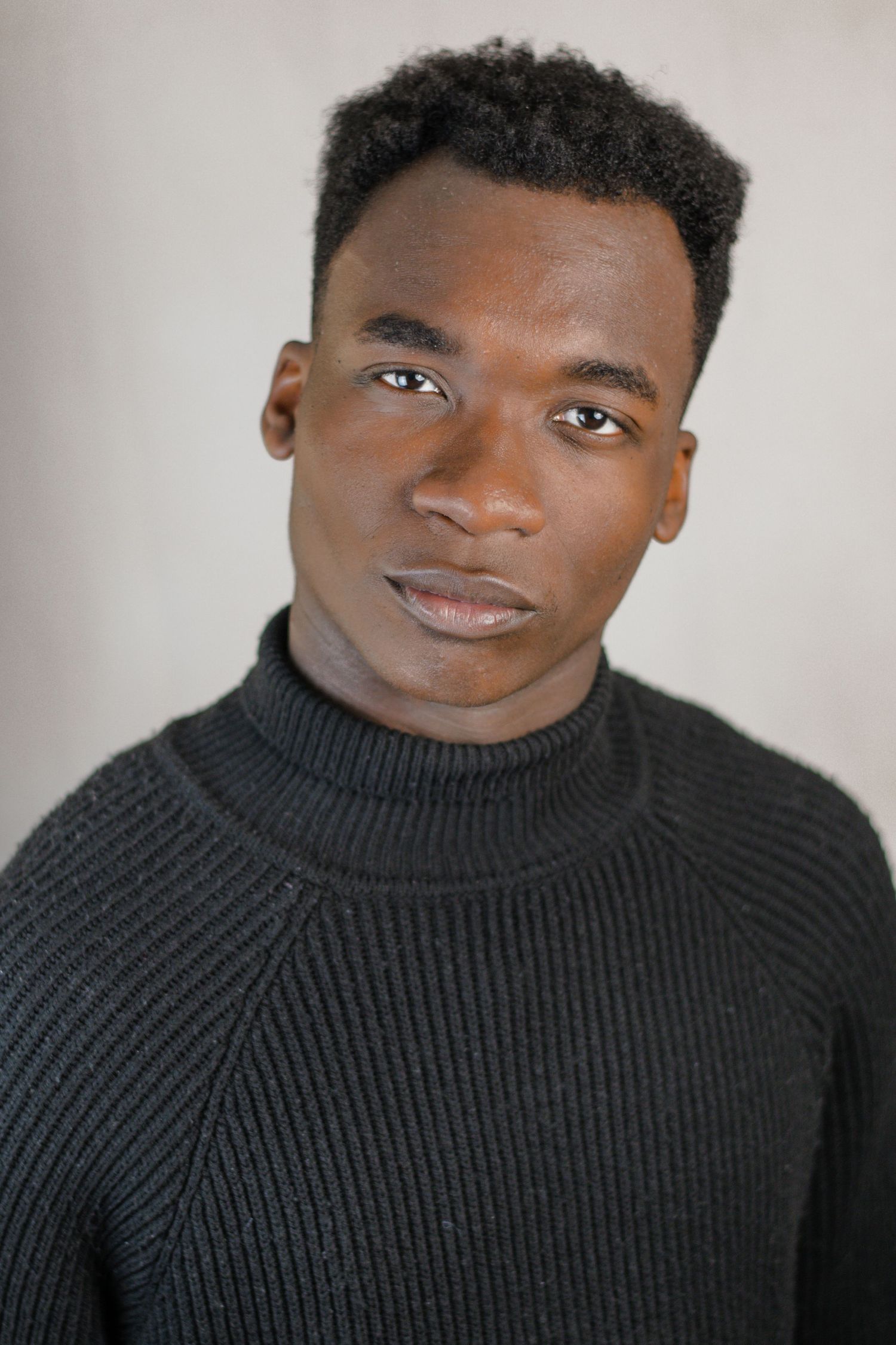 Modern portrait series featuring a black turtleneck sweater against a light grey background.
