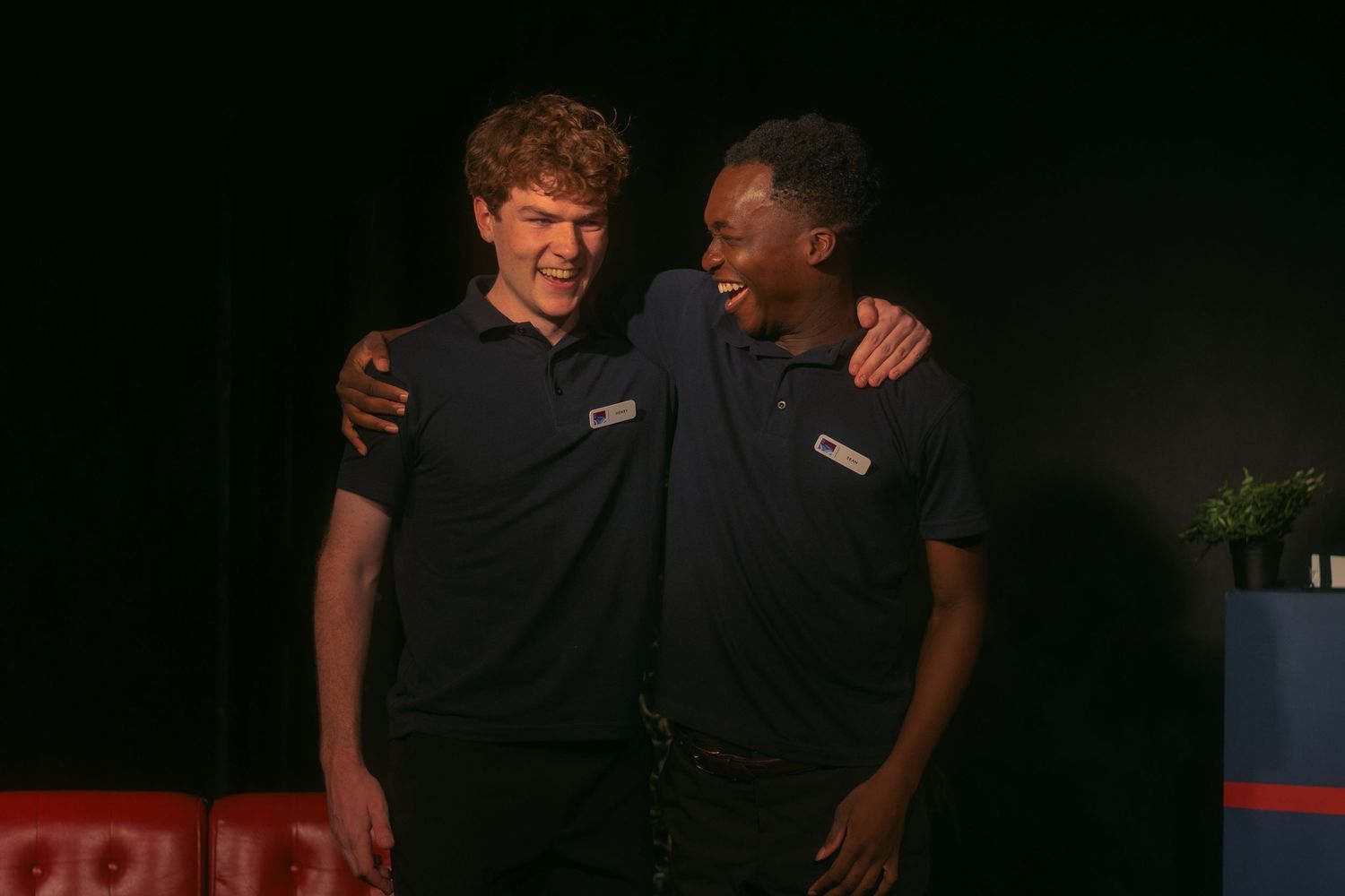 Colleagues in navy uniforms share friendly moment during workplace gathering.