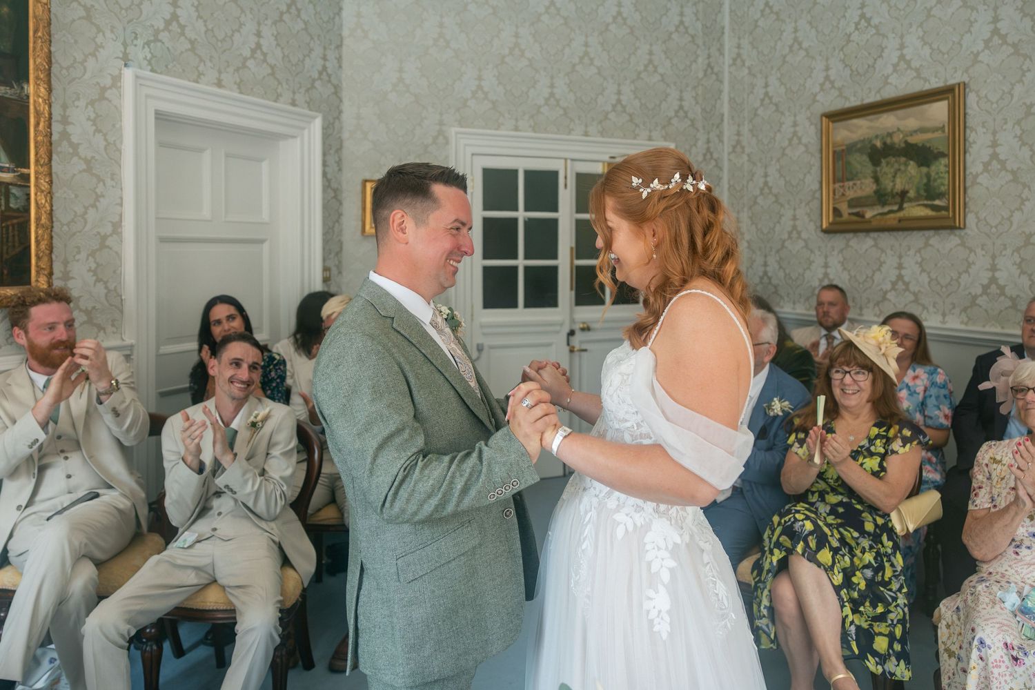 Bride and groom share first dance at elegant wedding ceremony with guests applauding in The Guildhall Bath.
