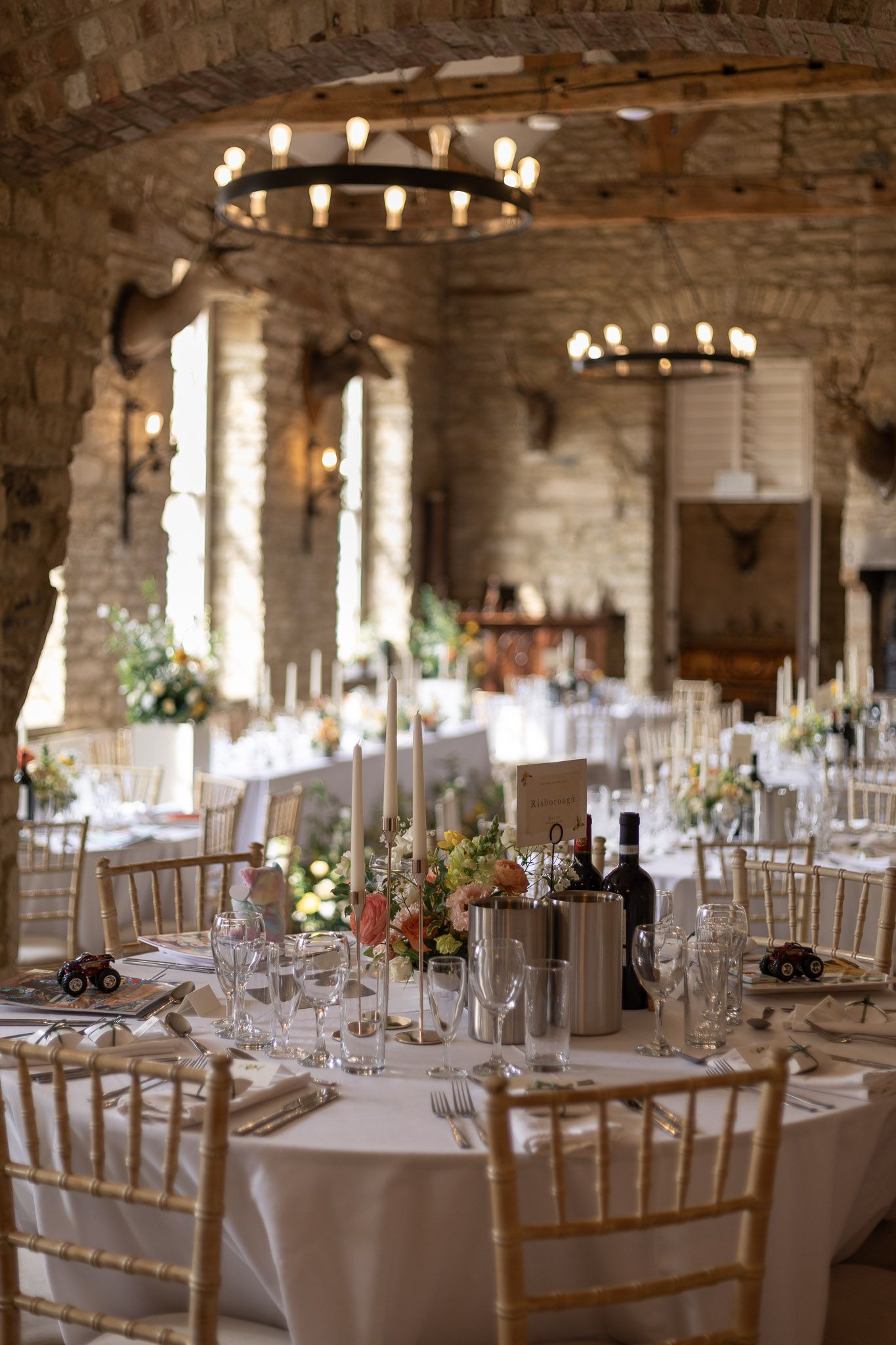 An elegant wedding reception venue with rustic stone walls and chandeliers.