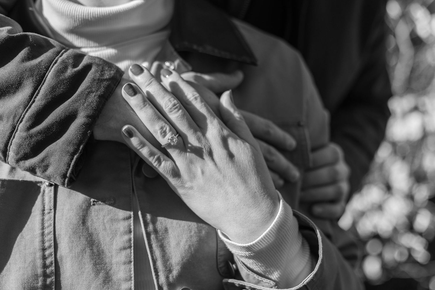 Close-up view of hands holding white coffee cups against a dark background.
