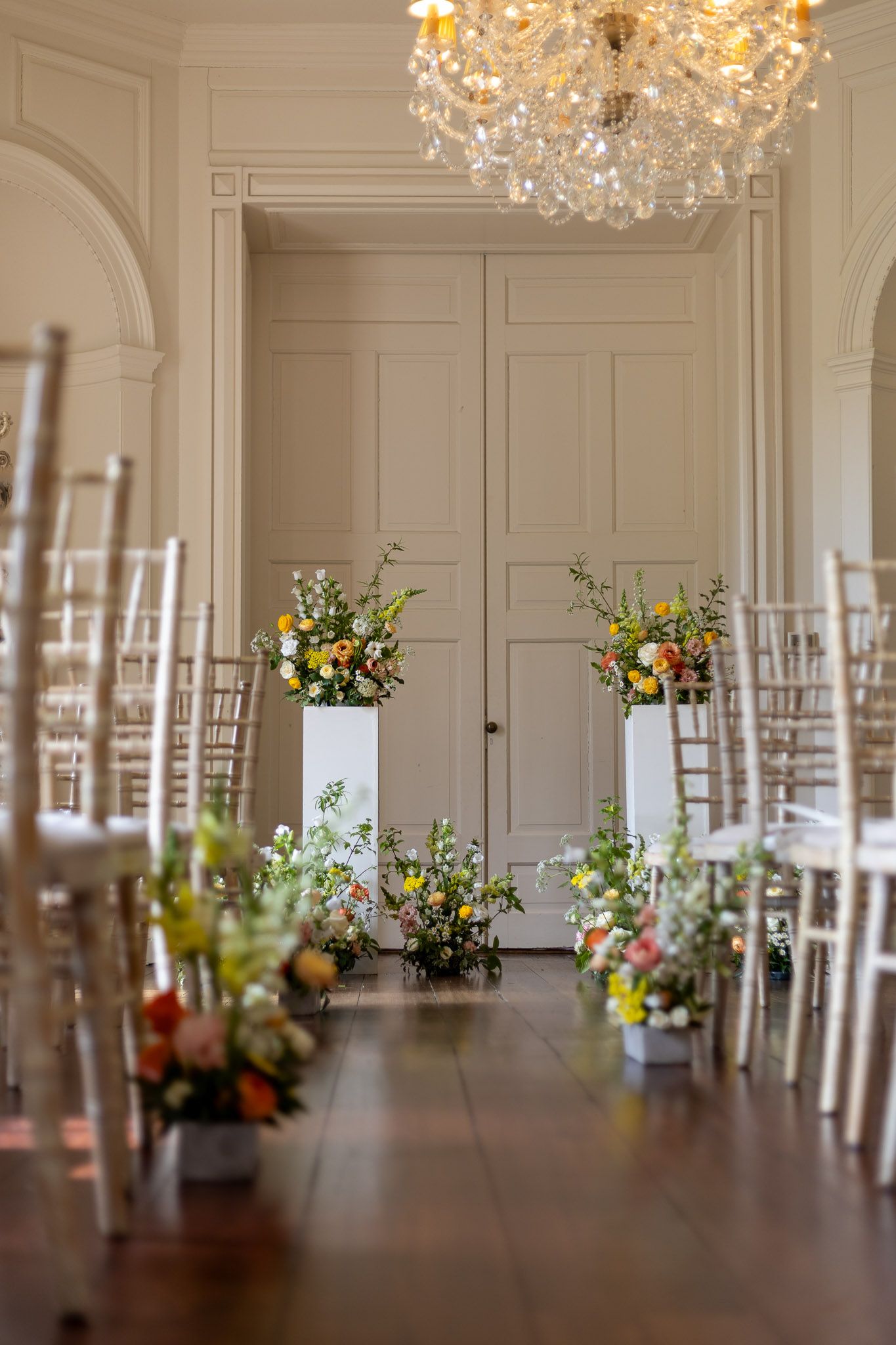 Close-up of a mixed floral arrangement featuring peach ranunculus, yellow roses and white blooms.