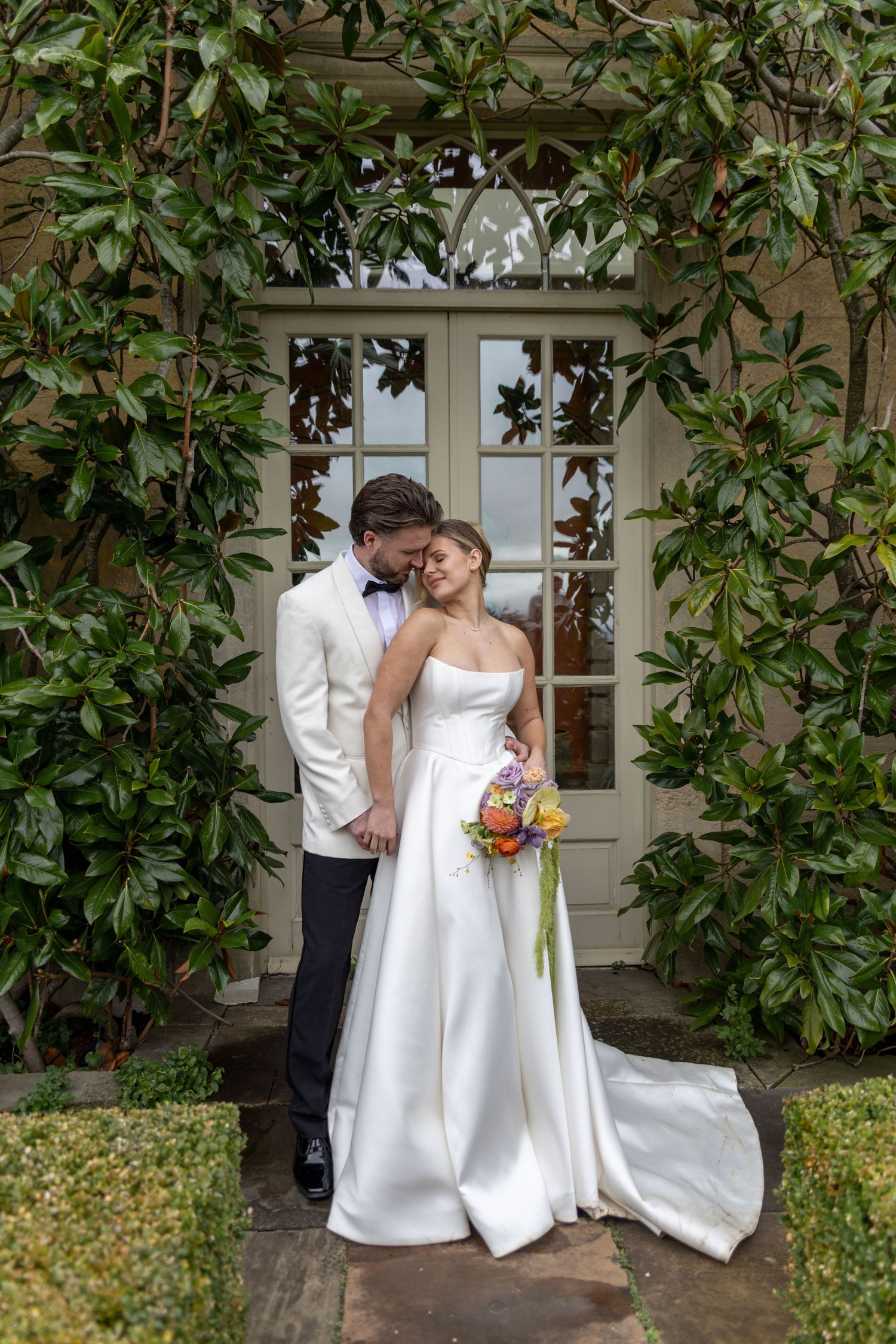 Elegant wedding photos taken against a lush magnolia tree backdrop showing romantic moments.