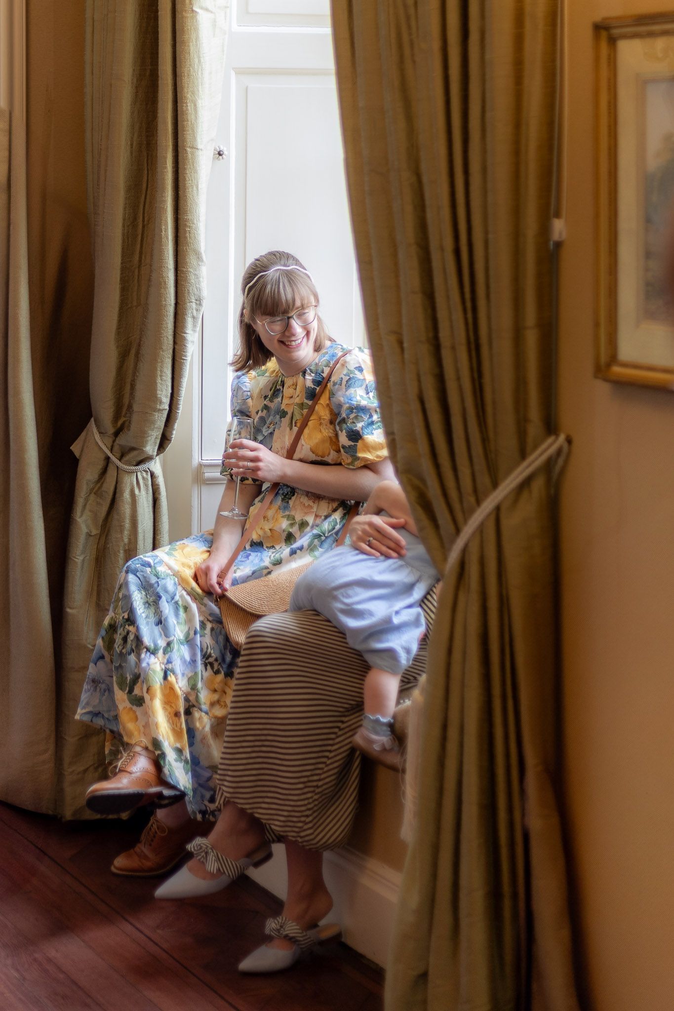Quiet moment captured in elegant room with brown curtains and hardwood floors.