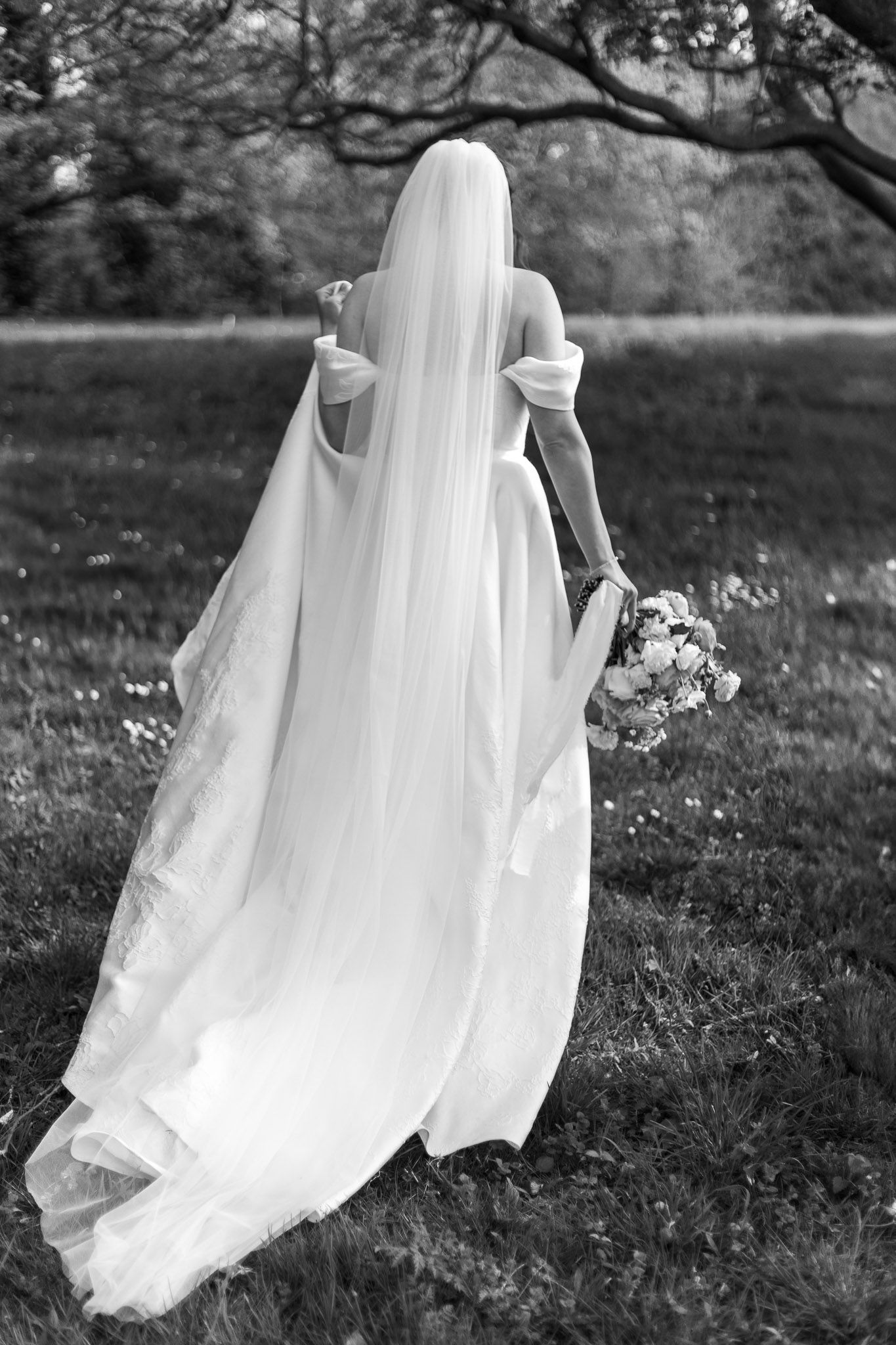 Black and white detail shot of a flowing wedding dress train in motion.