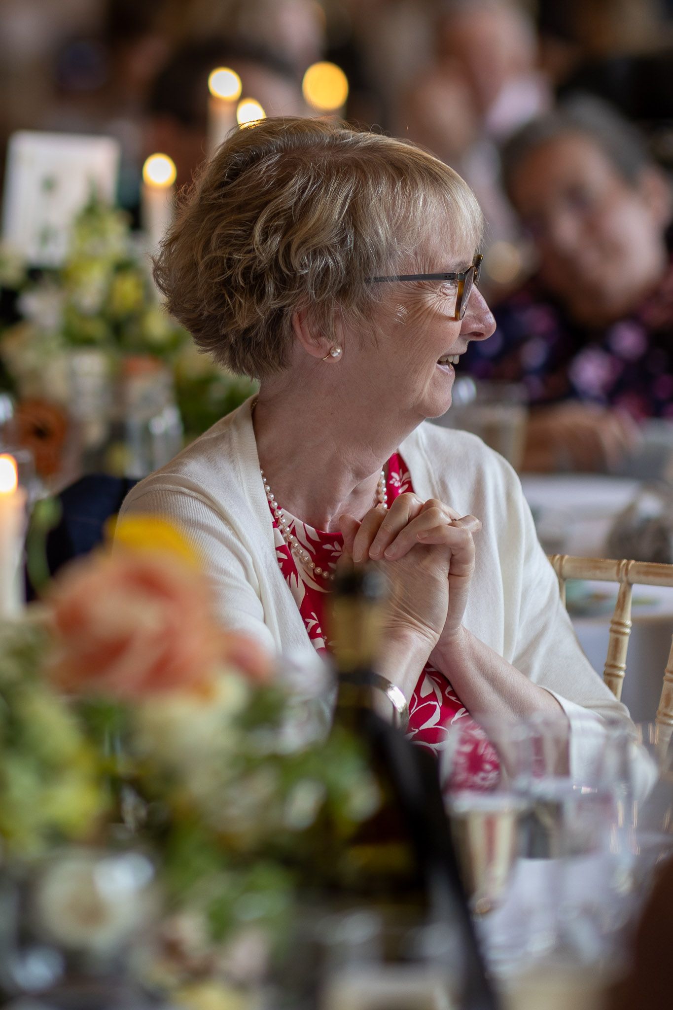 Wedding guest in white and red attire enjoying the reception celebration.