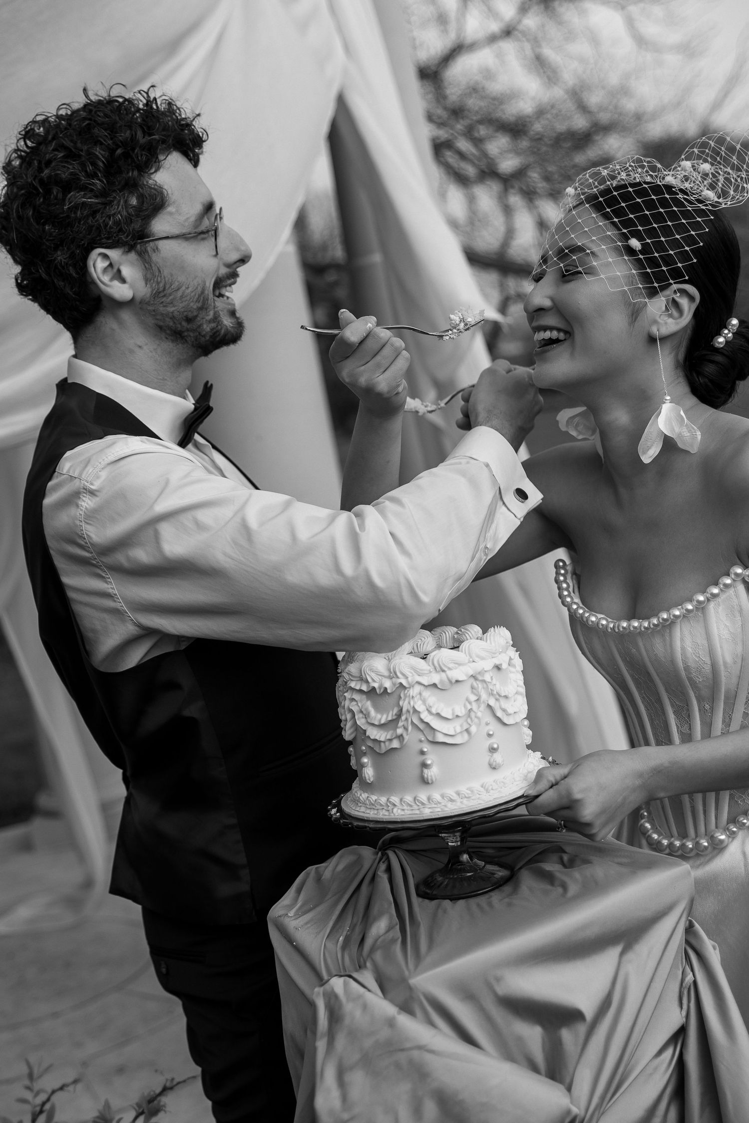 Black and white photo sequence showing a playful wedding cake smashing moment between newlyweds.