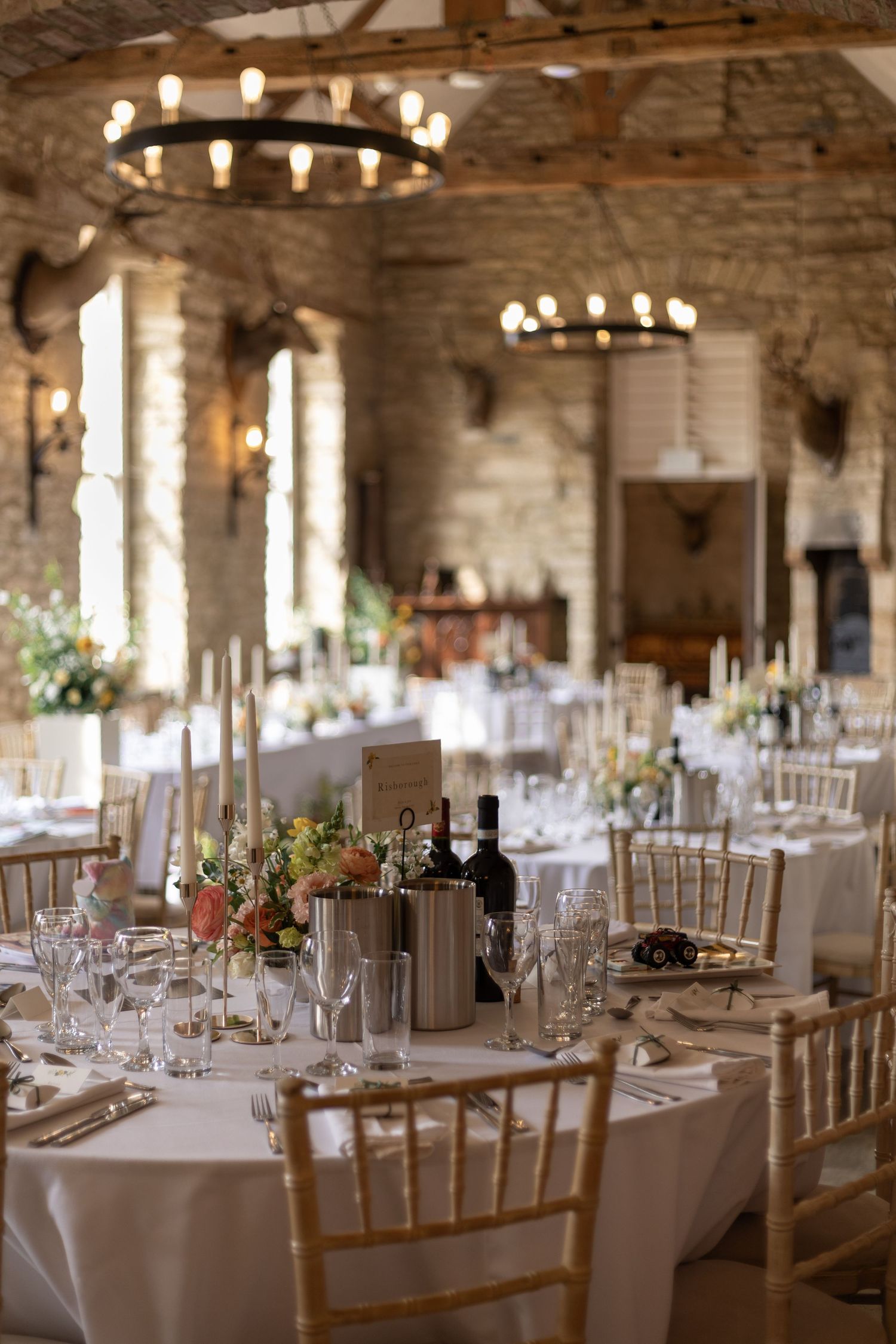 Rustic stone-walled reception venue set with tables and ambient lighting.