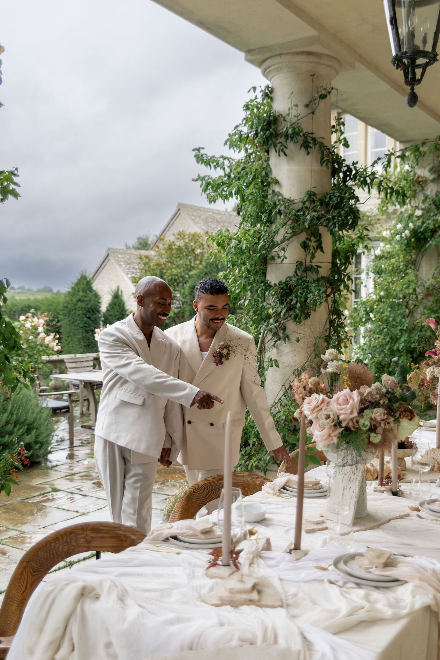 An elegant outdoor wedding reception table with white linens and floral arrangements.