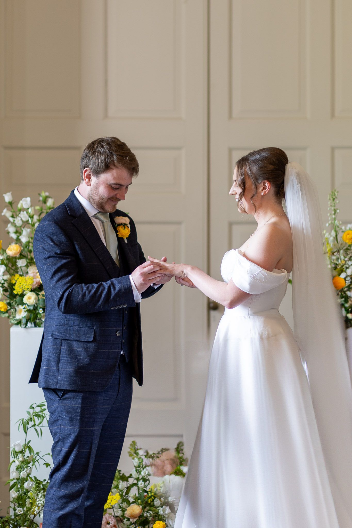 Romantic sequence of groom kissing bride's hand during first look in elegant venue.