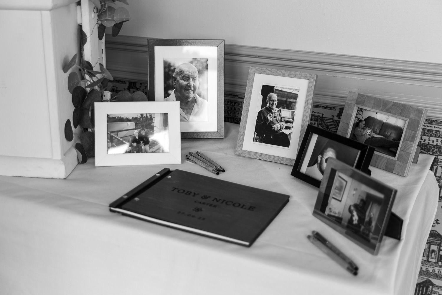 Black and white interior room with framed photographs on wall.