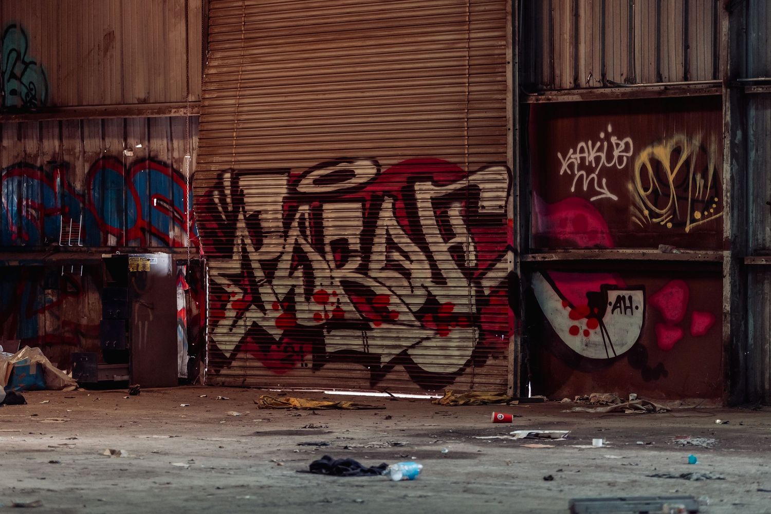 Urban graffiti art on rusty metal warehouse doors and walls.