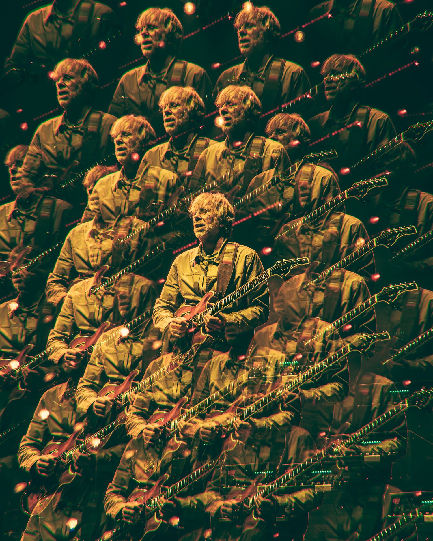 Multiple mirrored reflections of a guitar player performing on stage under dramatic lighting creating a kaleidoscope effect.