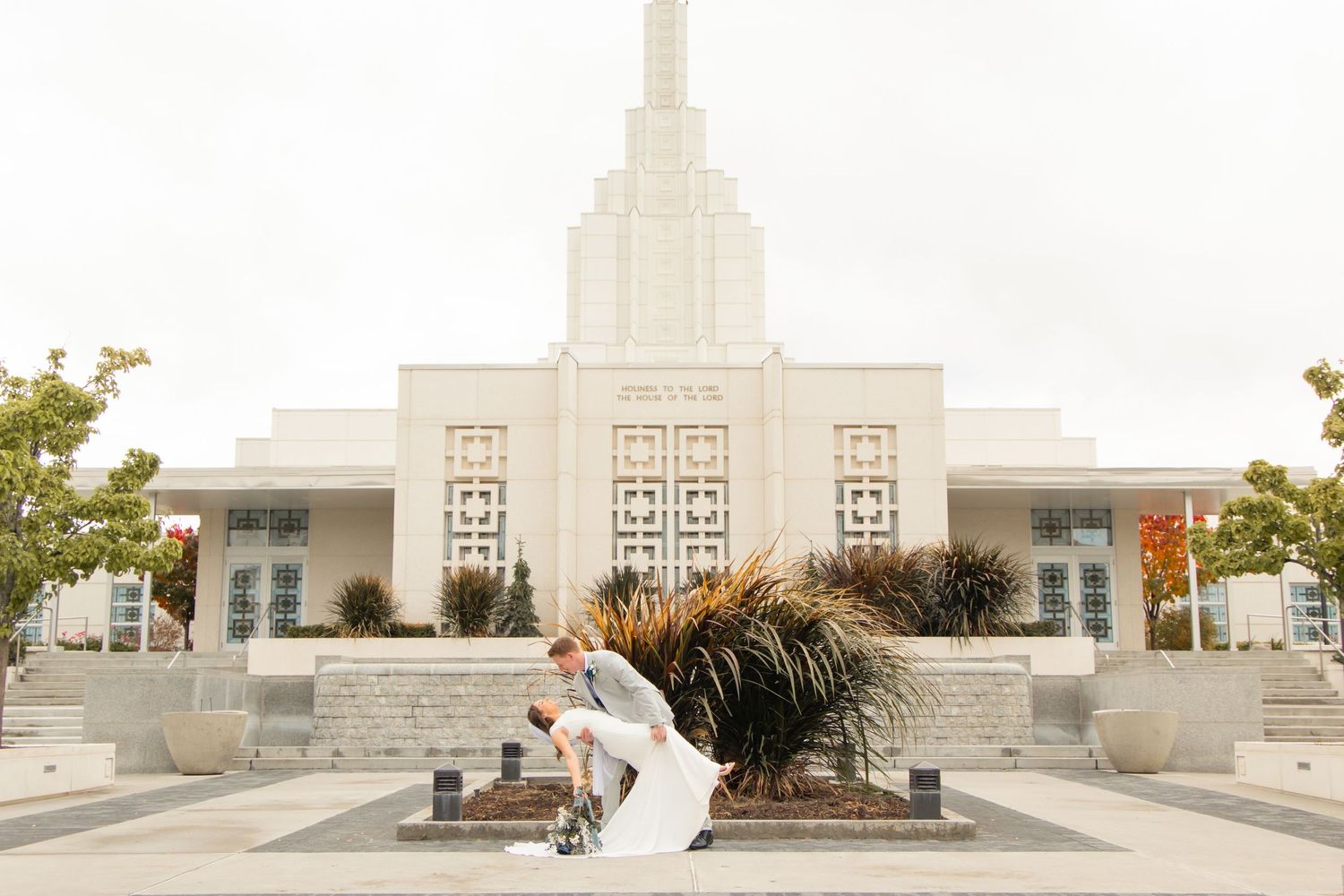 An elegant white temple building with art deco architectural details at sunset.