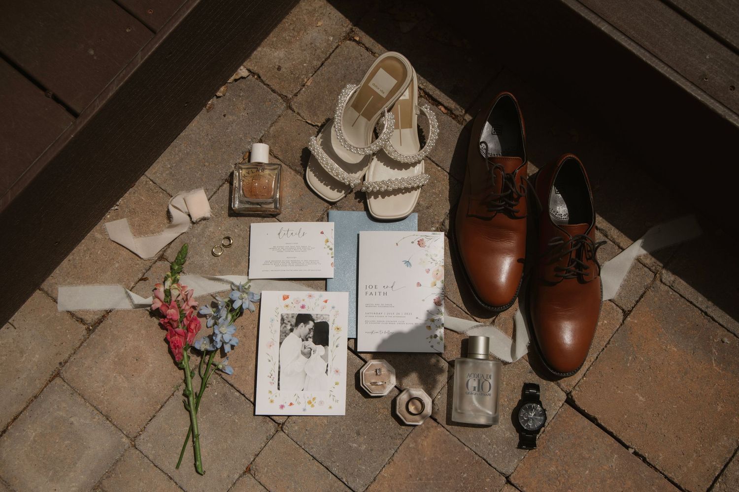 Romantic setup with candles, notes and flowers on wooden floorboards.