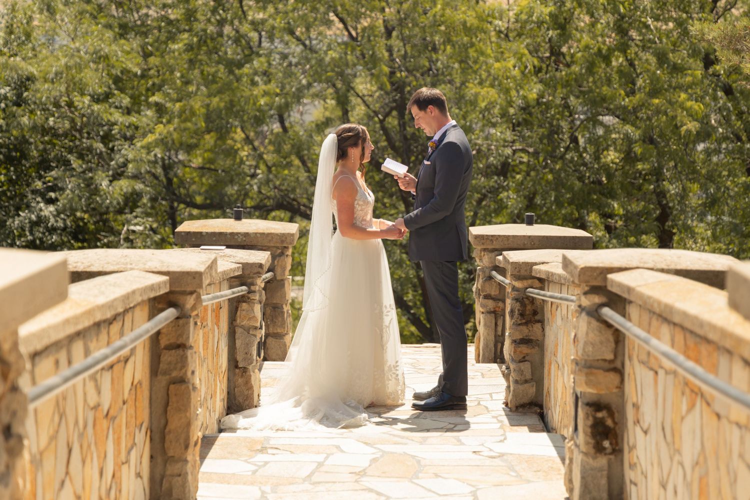 A romantic moment captured on a rustic wooden bridge surrounded by lush greenery.