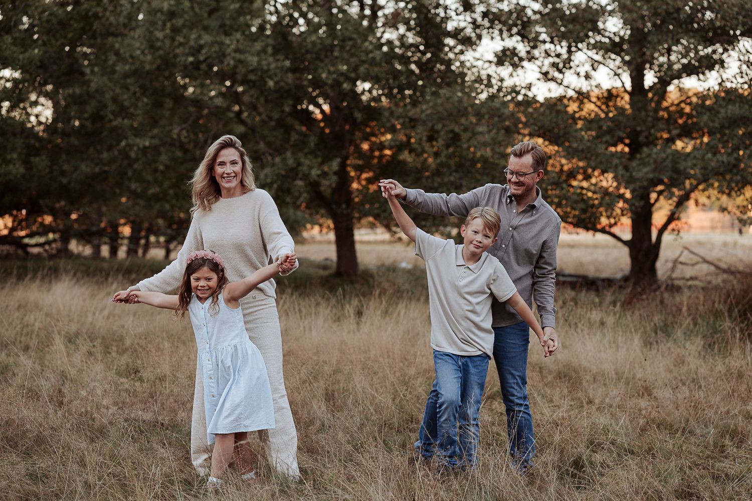 En familj leker på en äng i solnedgången