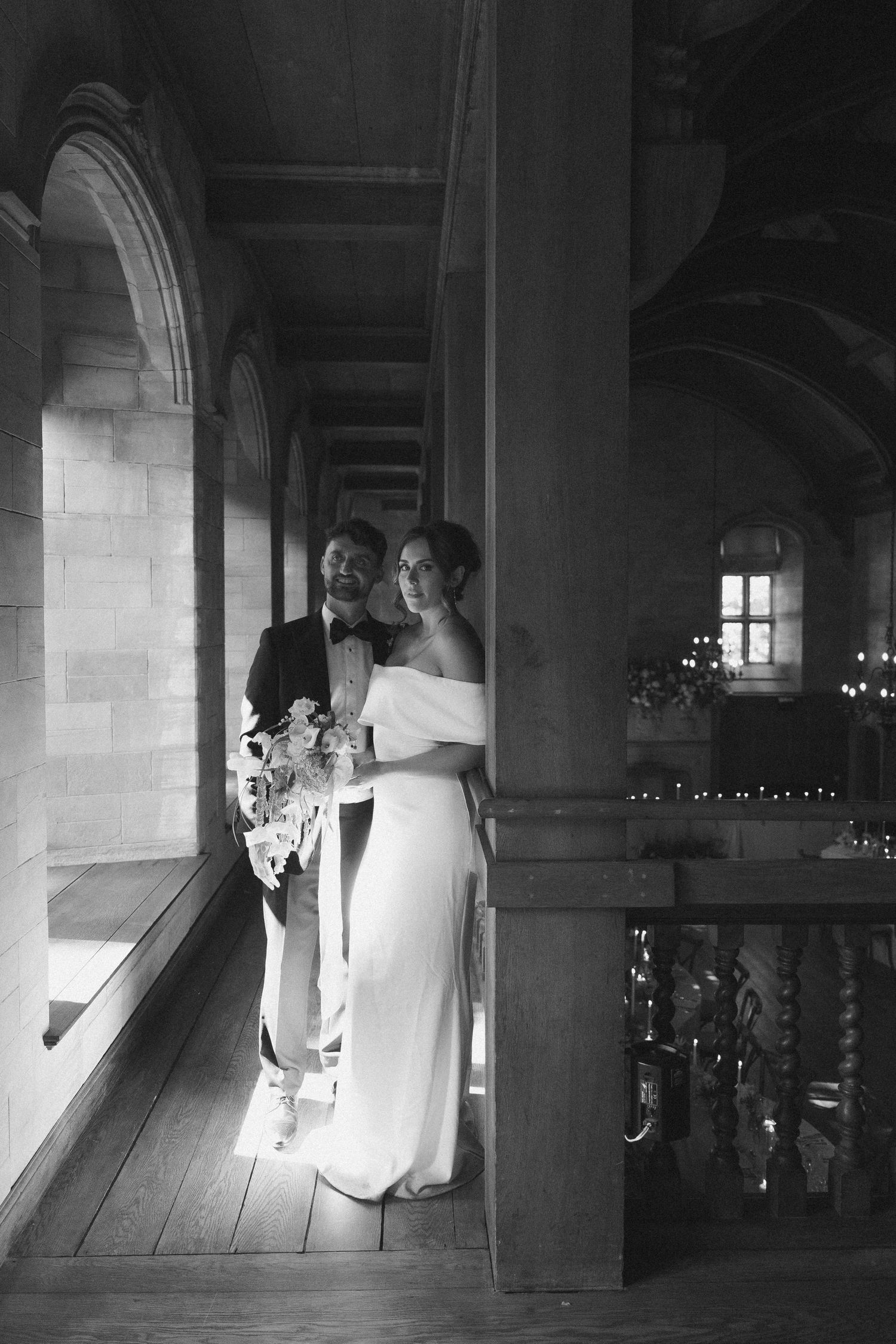 Black and white photo sequence showing a bride and groom walking down a sunlit stone corridor in a church.