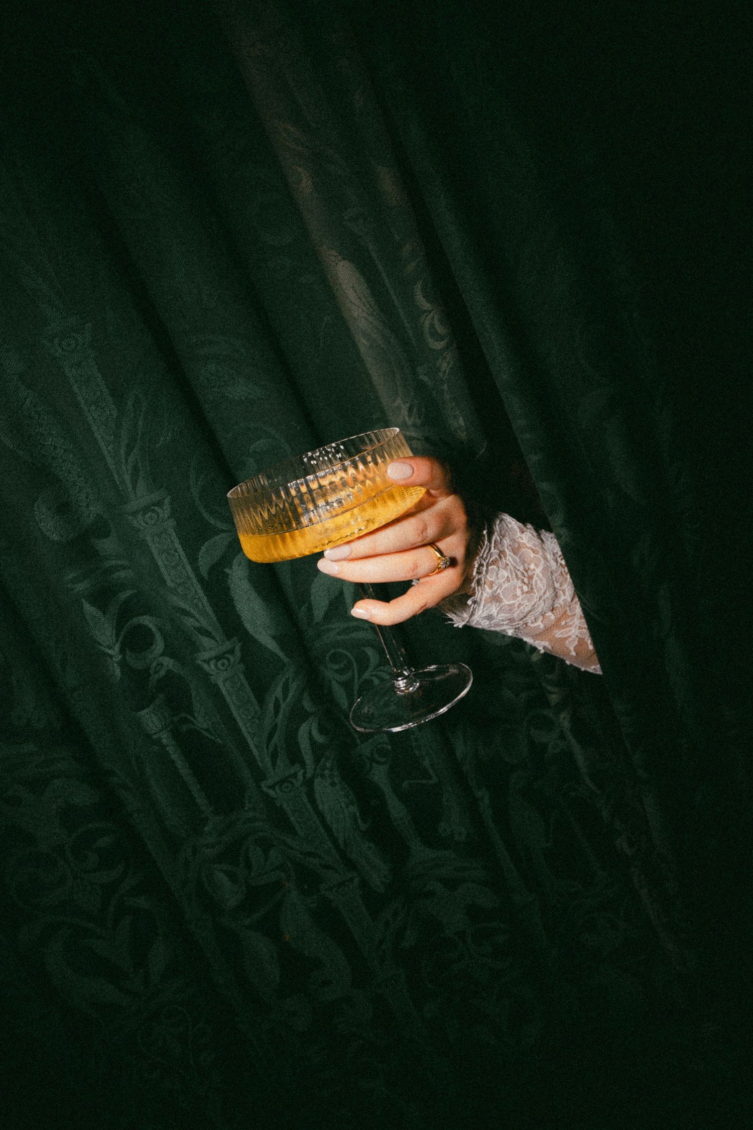 Champagne glass glowing in dark moody lighting creates an elegant ambiance.