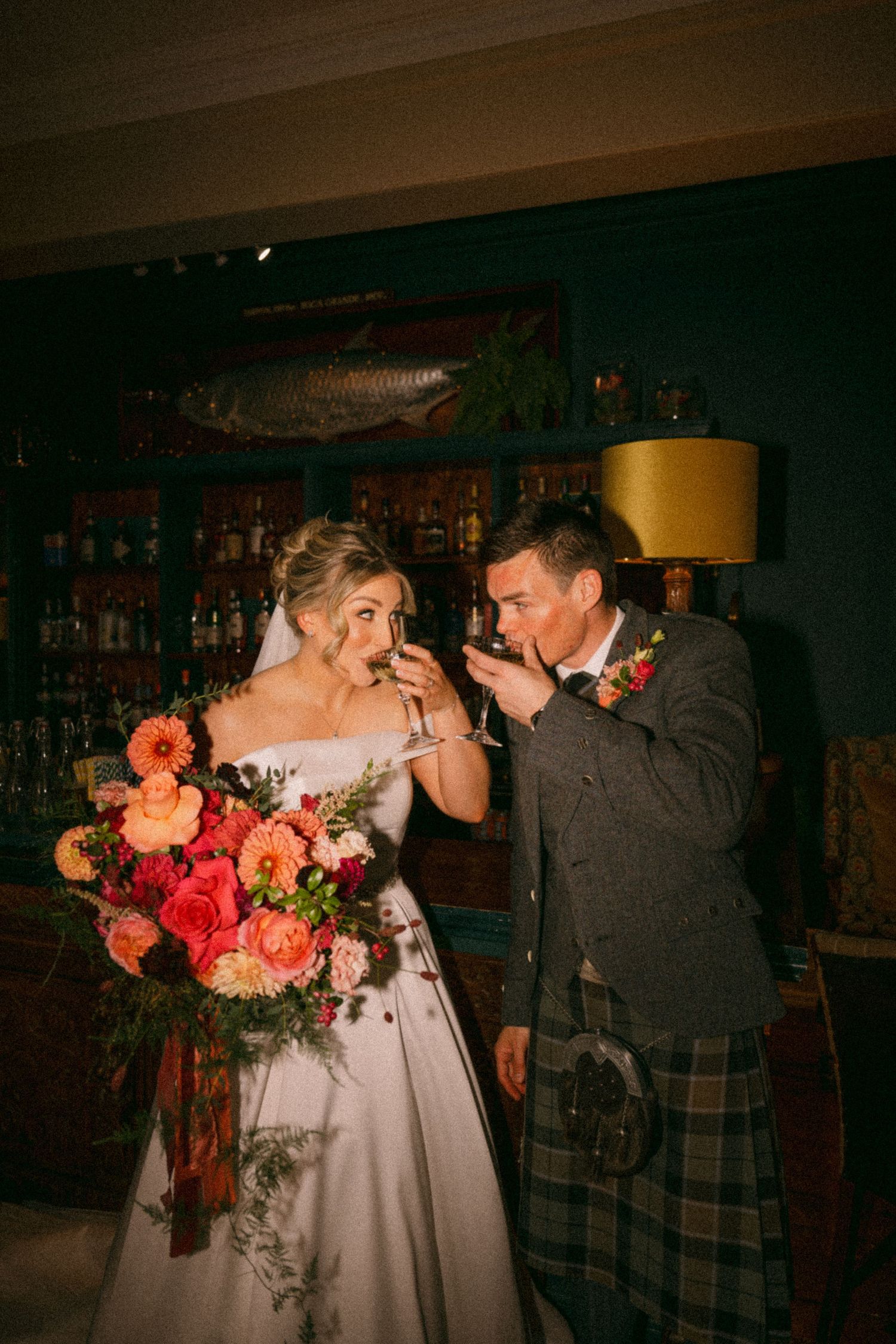 Scottish wedding, with the bride holding a vibrant coral bouquet. Aberdeen wedding photographer, raemoir house wedding
