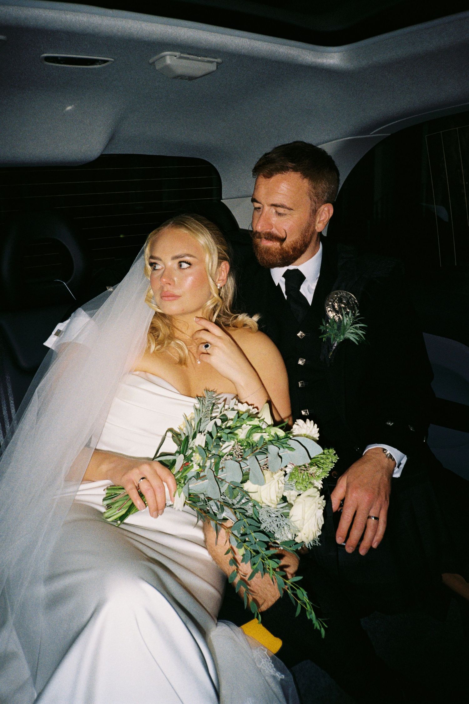 A series of intimate wedding photos showing a couple embracing in the back seat of a car with a bridal bouquet.
